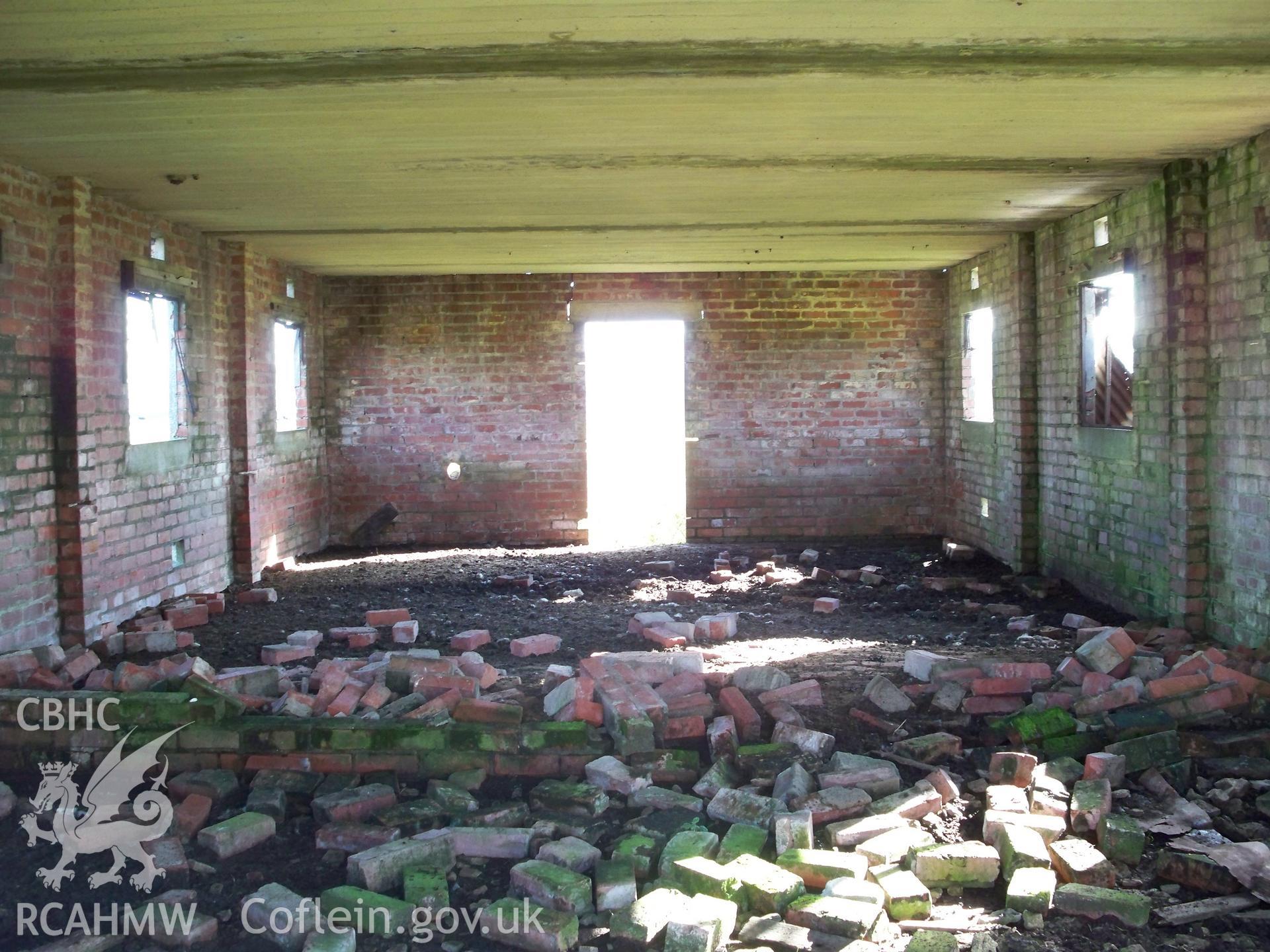 Interior revealing demolished central brick partition and underside of concrete roof