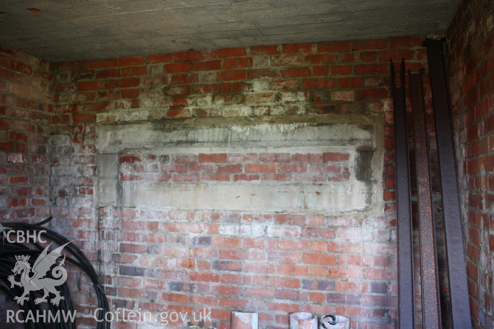 Interior of southern enclosed bay used as store showing bricked up observation slit