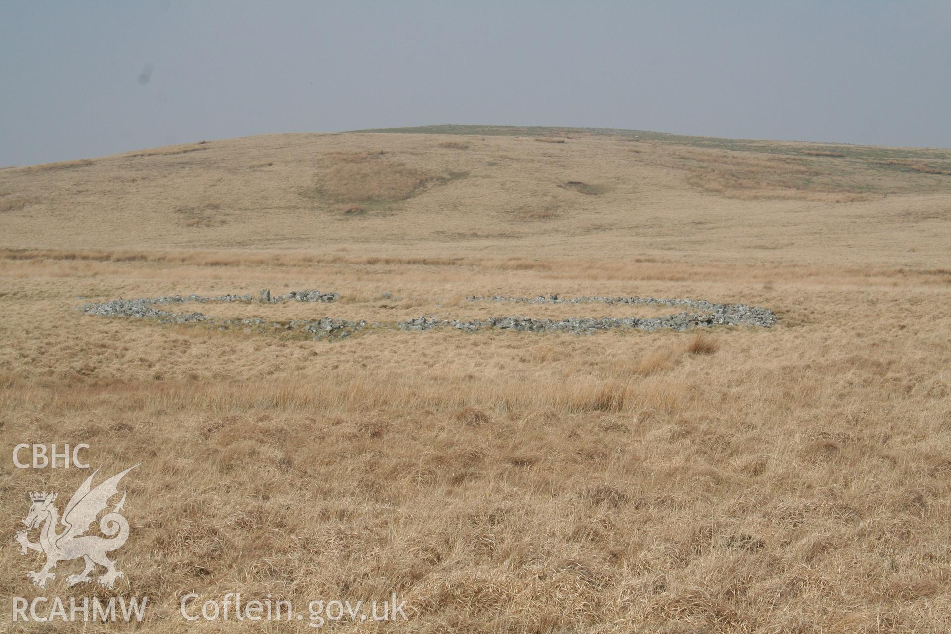 Ring cairn in rolling moorland, seen from south; the ring is about 25m in overall diameter.