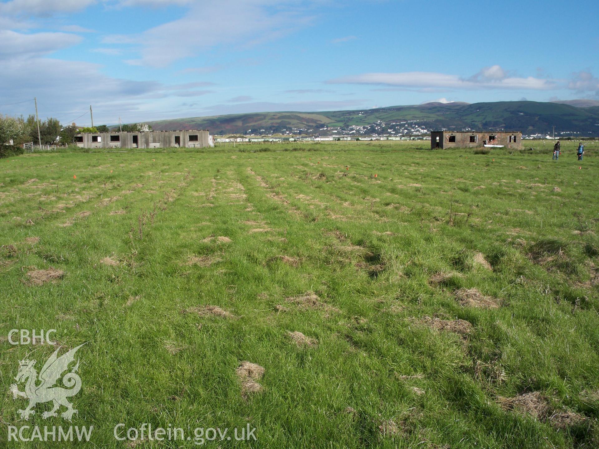 View looking north across the remaining hut platforms to buildings NPRNs 408011 and 408399