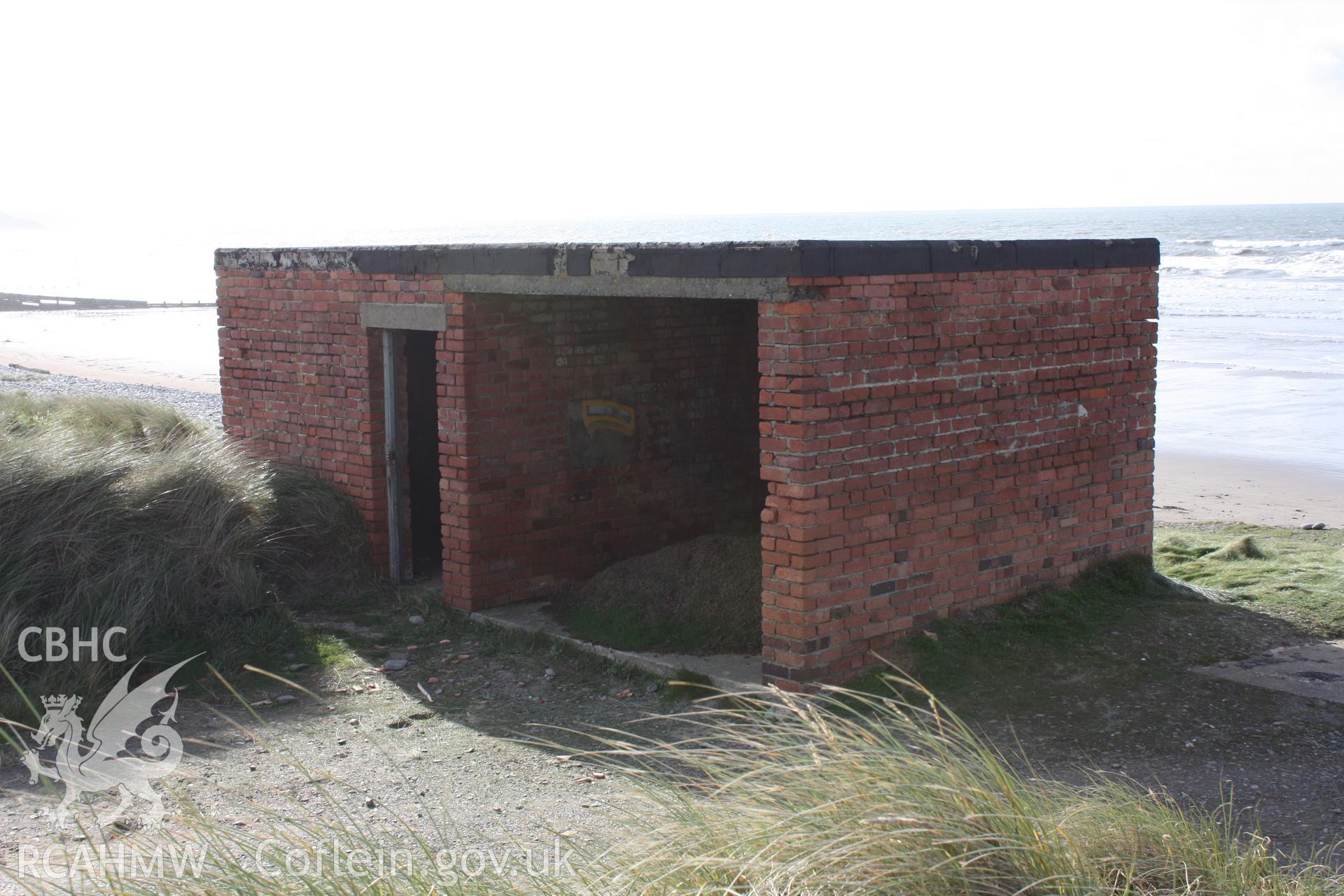 Landward facade revealed the two bays (the northern open, the southern enclosed with doorway) and to the left of view the concrete base foundation (possibly for the camera or radio mast).