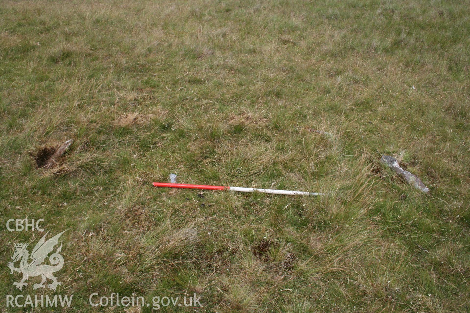 Ring of edge-set slabs partially exposed to the immediate east of the cairn; 1m scale.