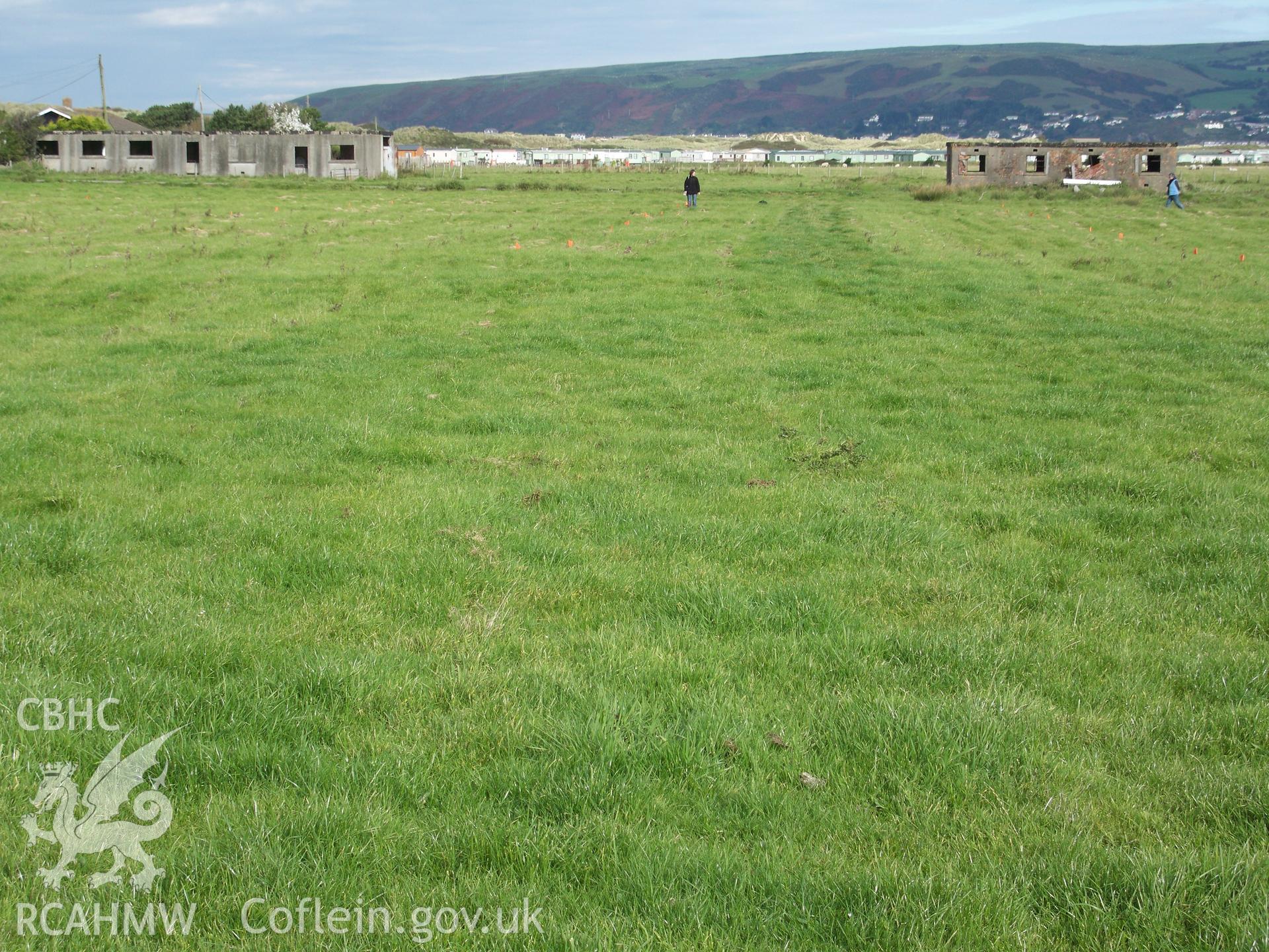 View looking north across the remaining 12 hut platforms with corners being outlined by RC Staff with survey flags