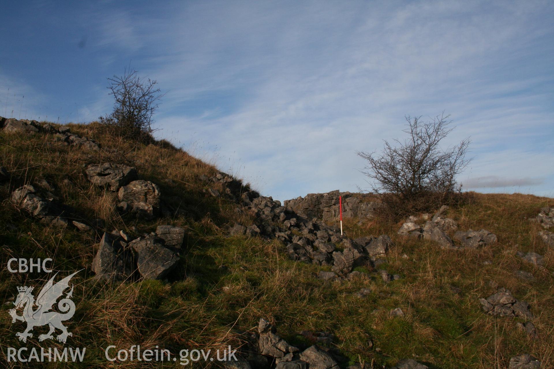 View of northern rampart and ditch from the south-east; 1m scale.