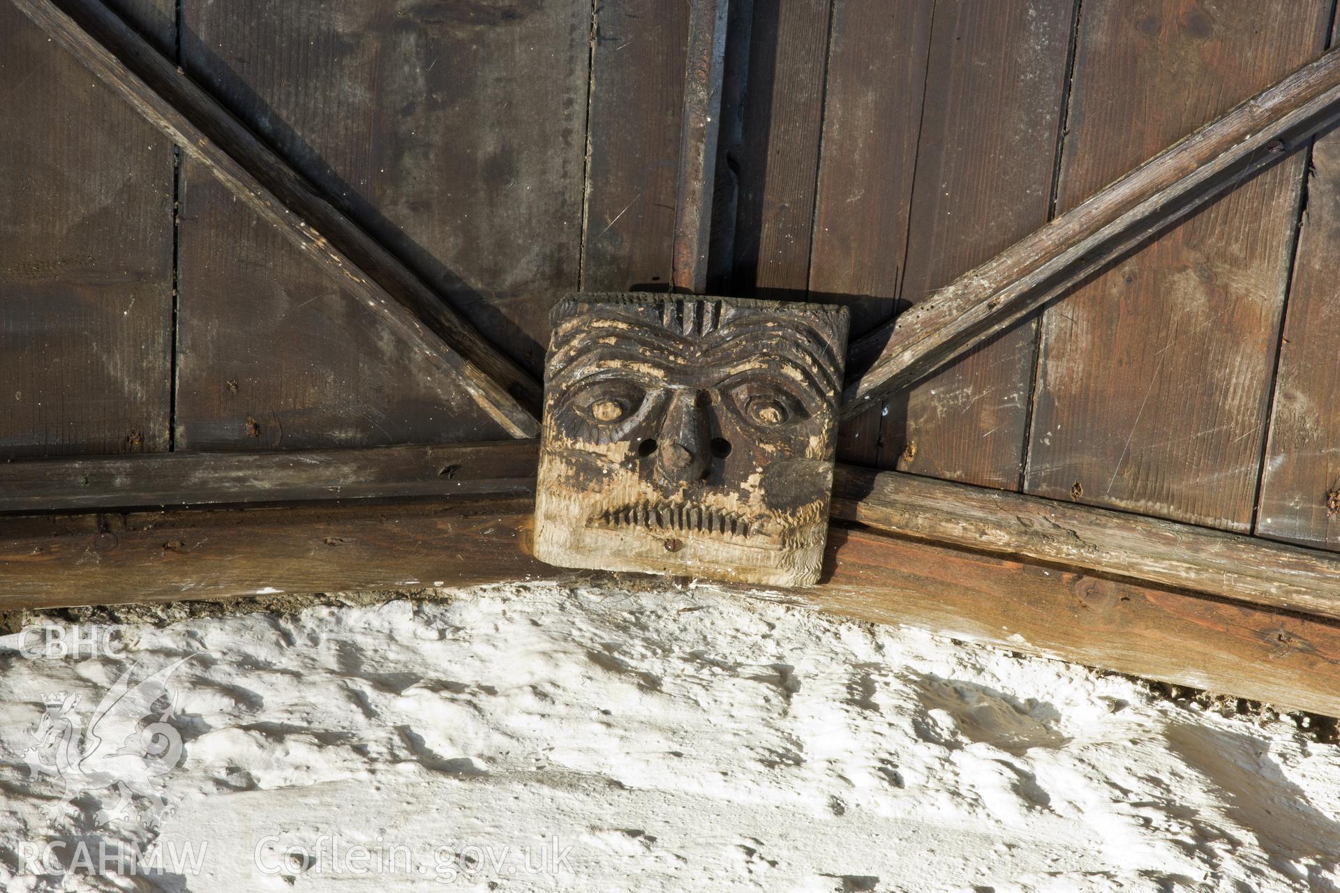 Carved face on ceiling above altar.