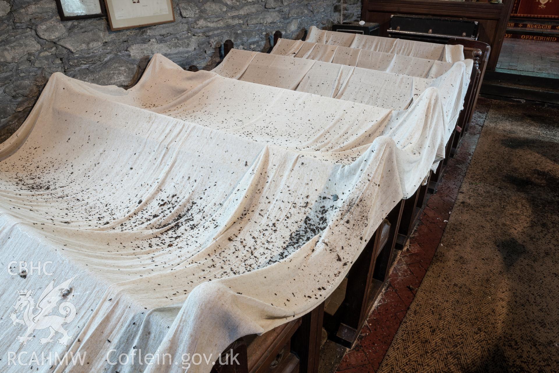 Pews with protective sheets, covered in bat droppings