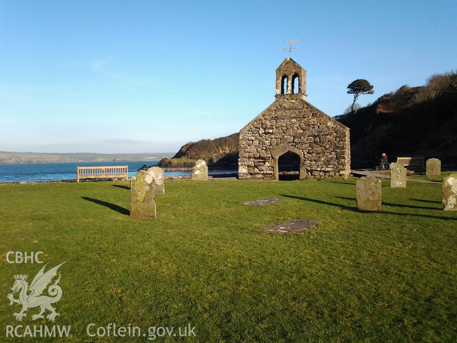 West wall of St Brynach's Church with surrounding gravestones.