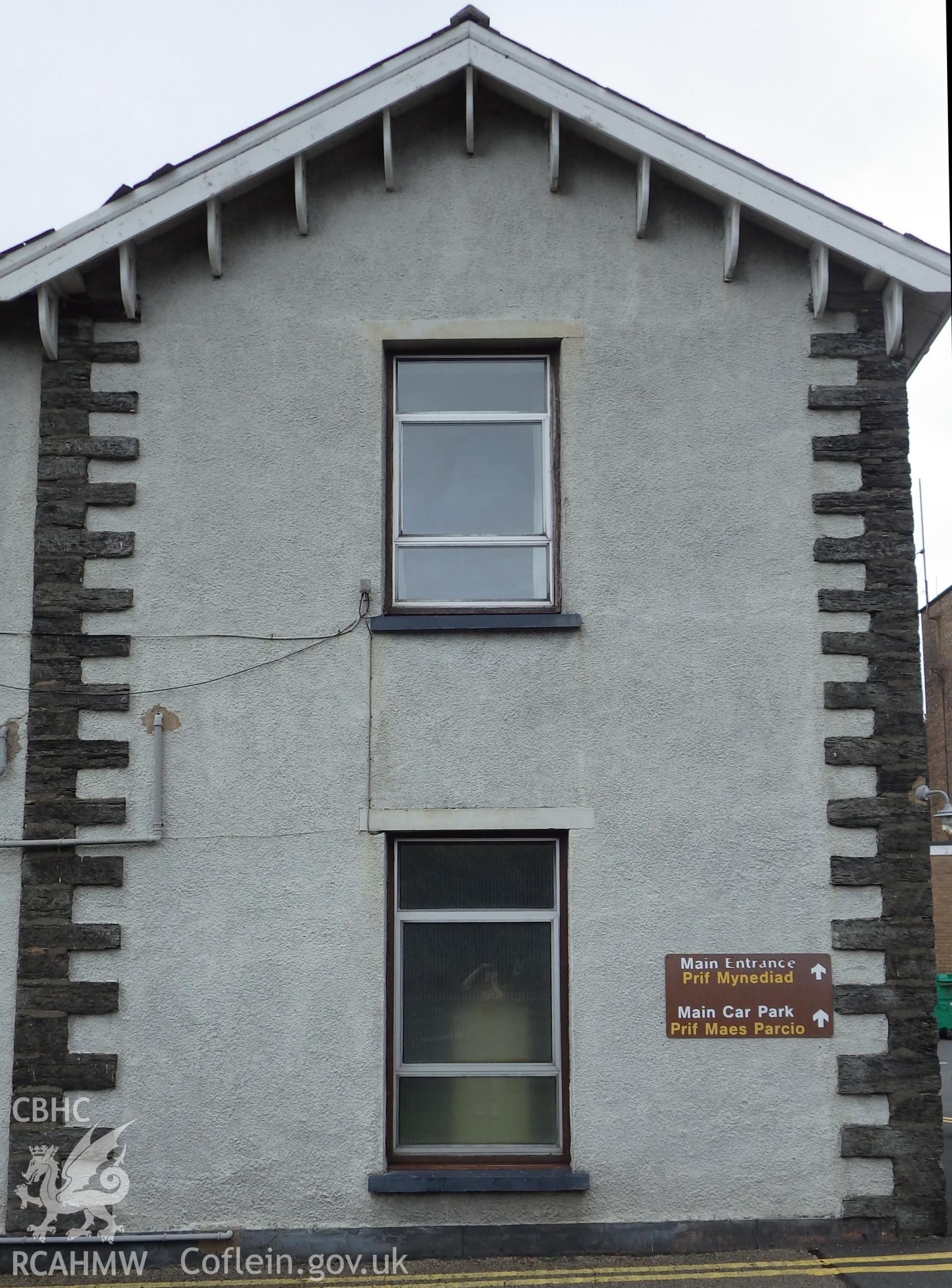 Detail of one bay of front elevation showing stone quoins and decorative eaves