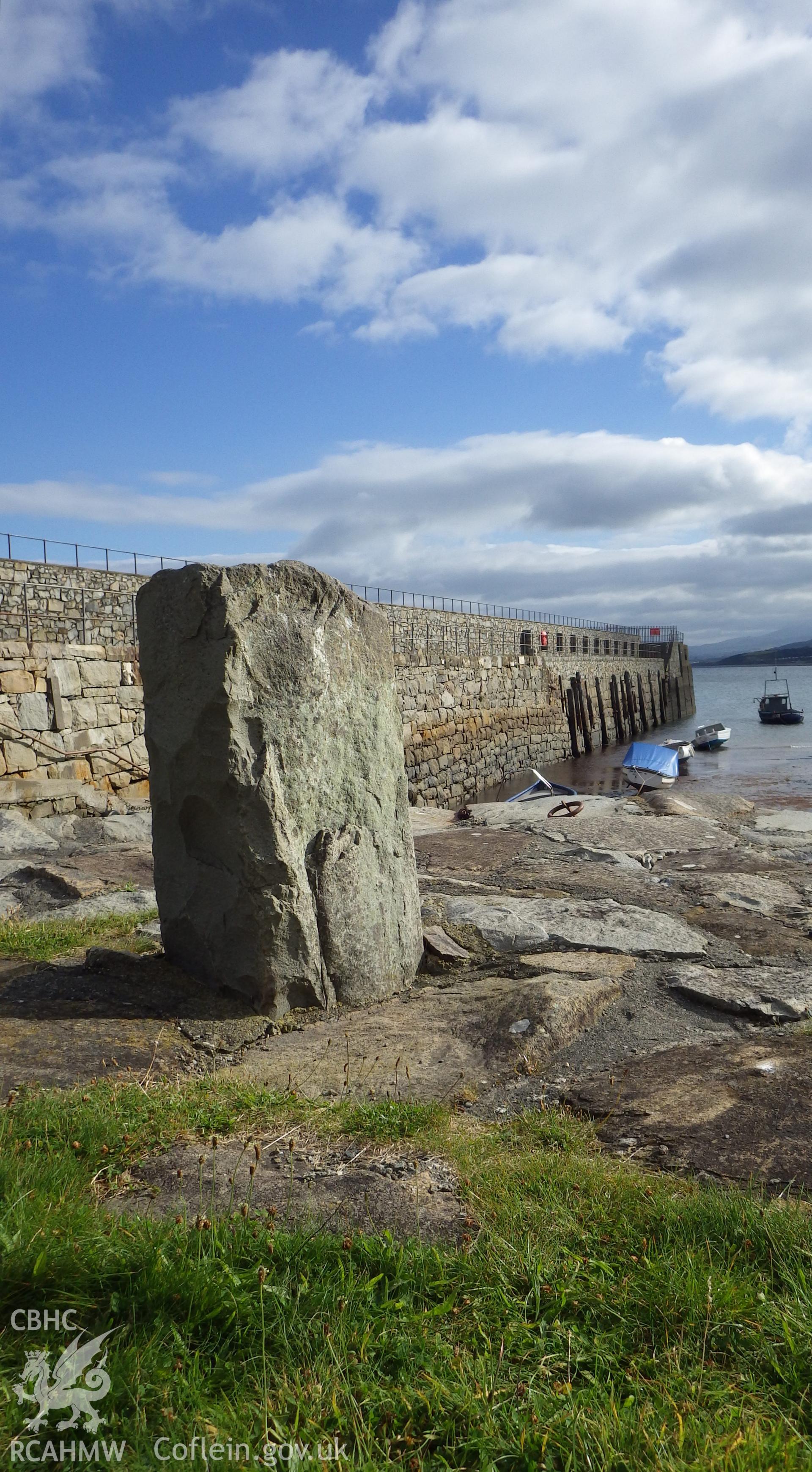 View along the inside of the harbour harbour with stone mooring bollard at entrance to small dock in foreground