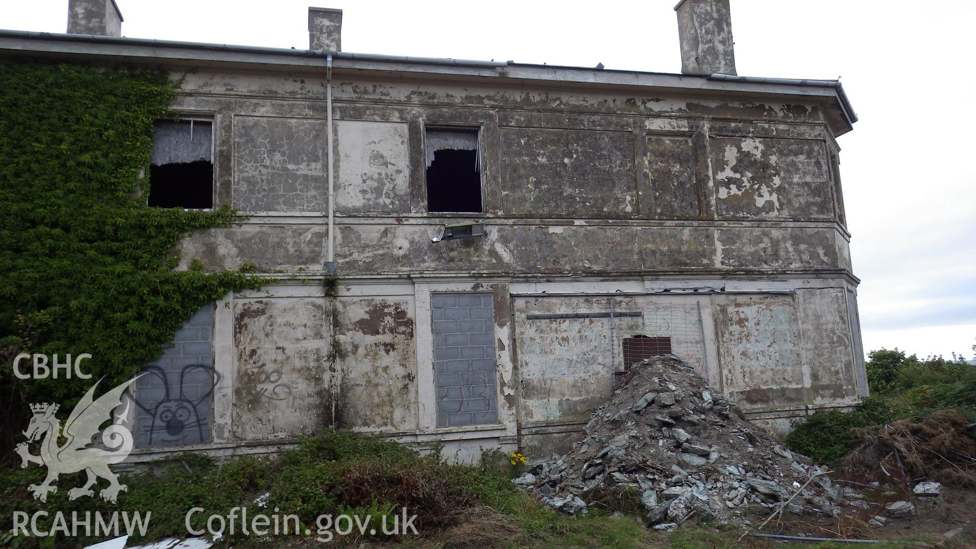 Exterior of southern wing viewed from south showing blocked lower windows, rubble piles and graffiti