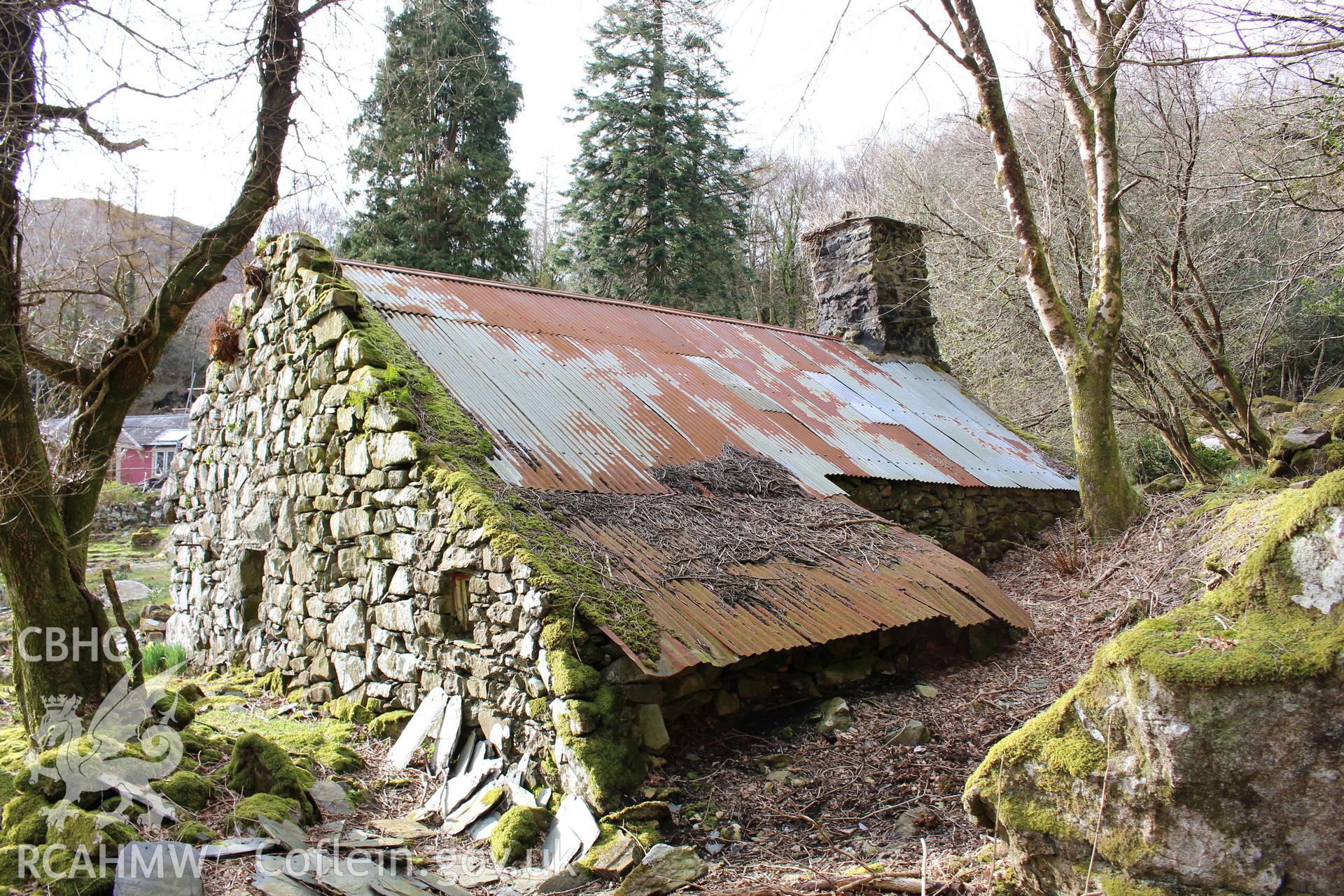 Exterior: 3/4 view of east and south elevations, showing Oerddwr-isaf's positioning in the bank.