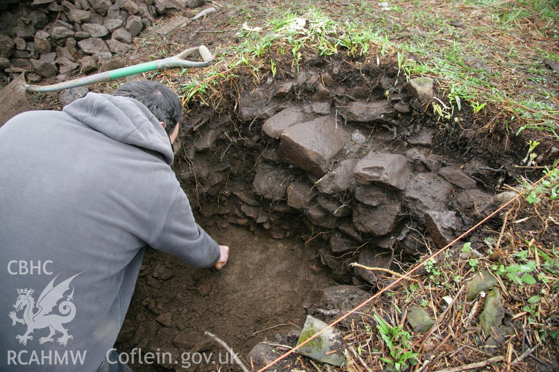 Skomer Island excavation of a burnt stone mound, Hut Group 8. Excavation at the external face of western round house, hut group 8, context 109