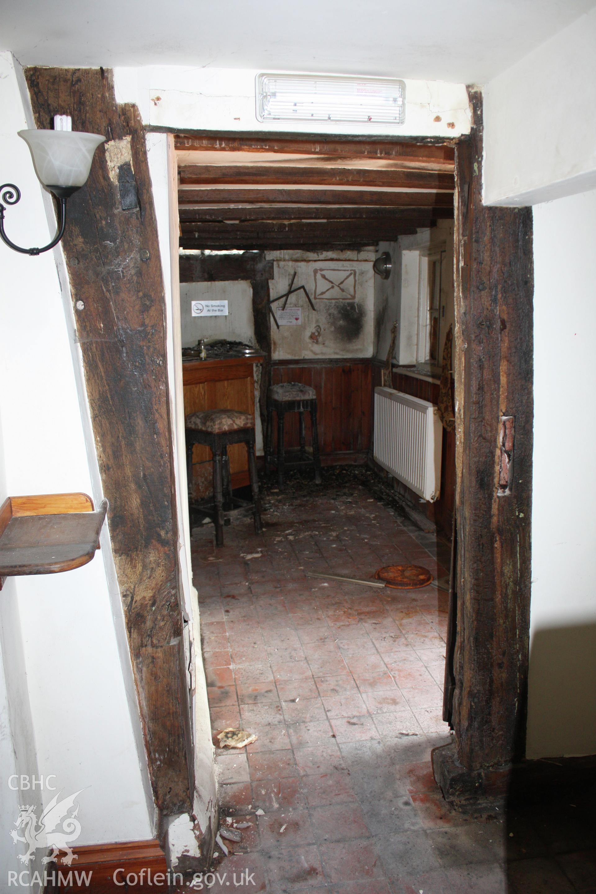 Re-used timber studs, in doorway beside fireplace