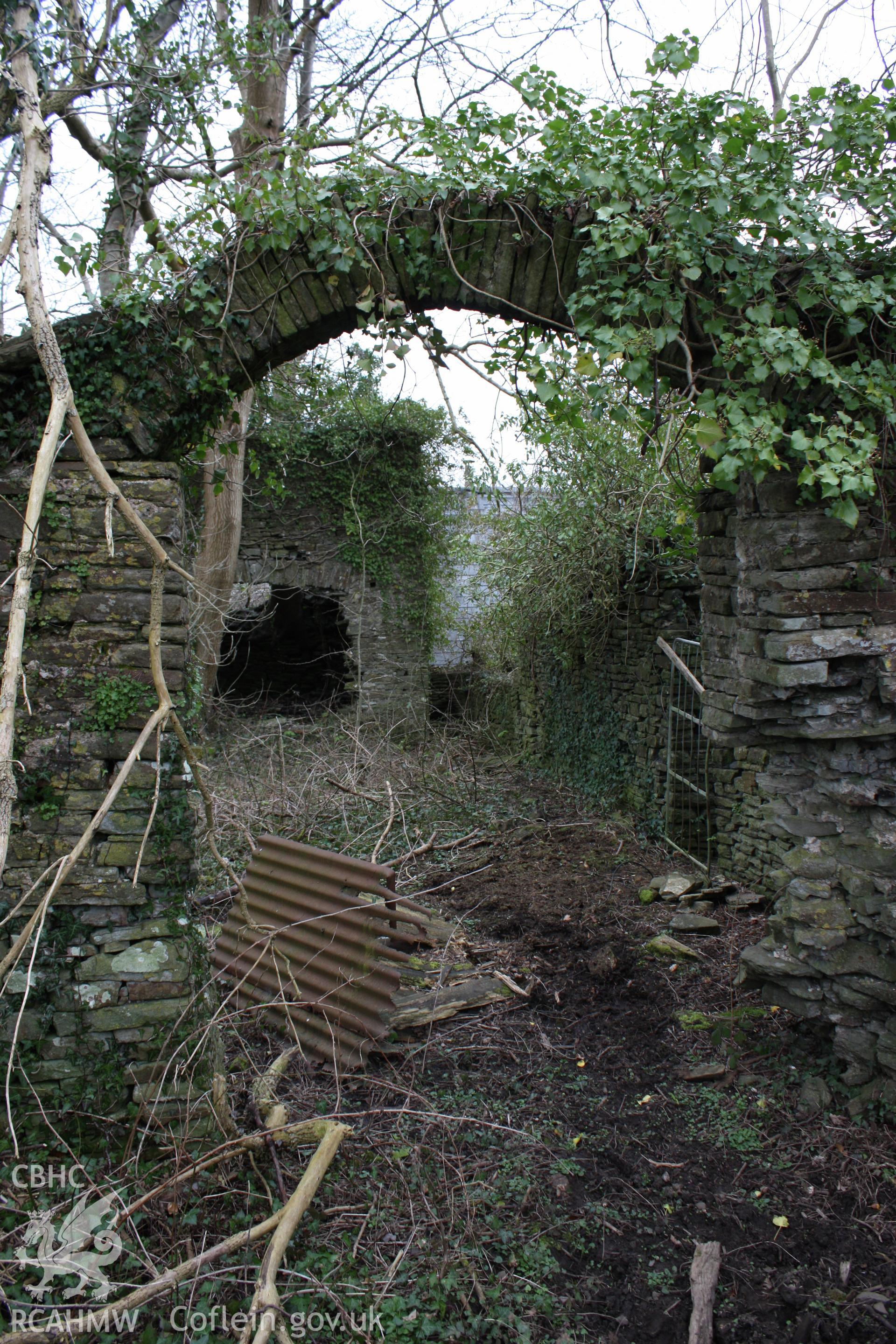 Plas y Bettws, Bridgend. Arch through courtyard wall with entrance of manor house opposite.