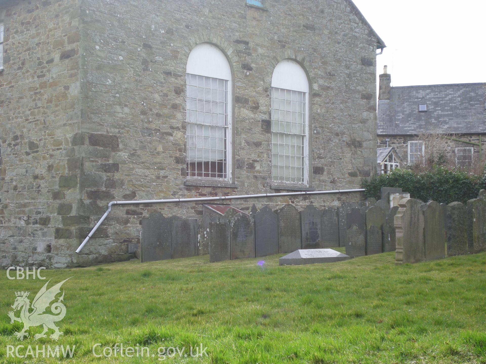 Colour photograph showing rear gable end and gravestones.