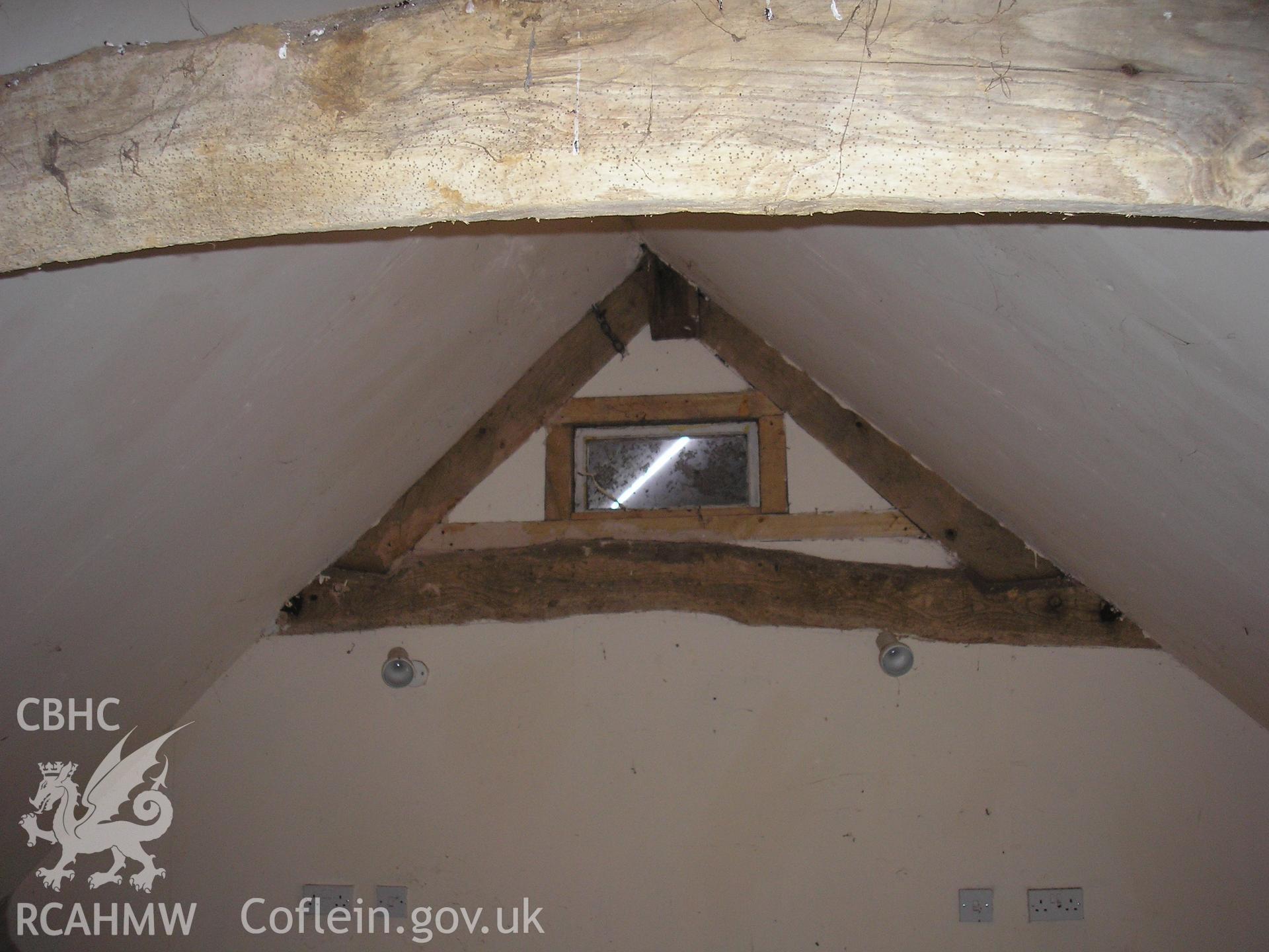 Interior of barn showing roof timbers and gable window