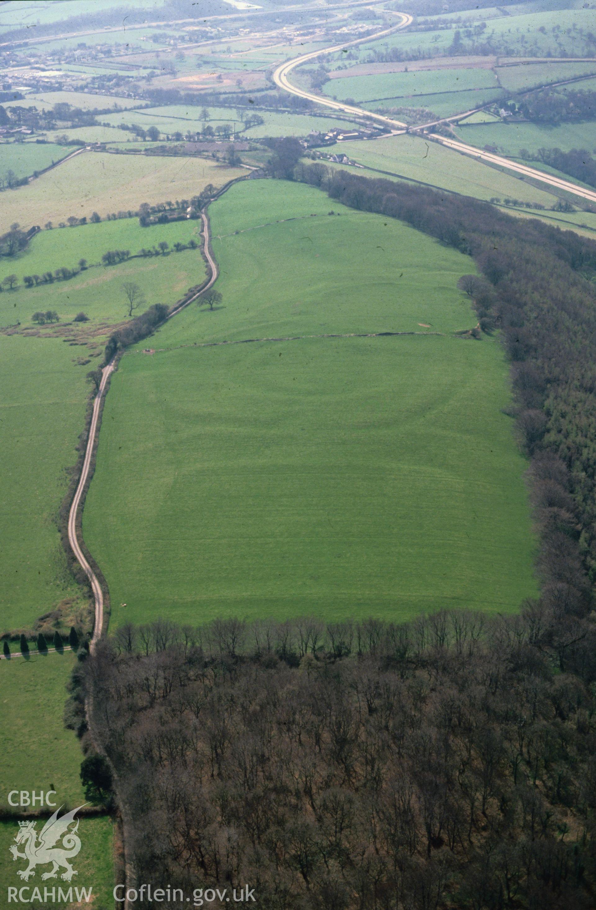 Slide of RCAHMW colour oblique aerial photograph of Coed y Caerau Enclosures, taken by C.R. Musson, 26/3/1990.