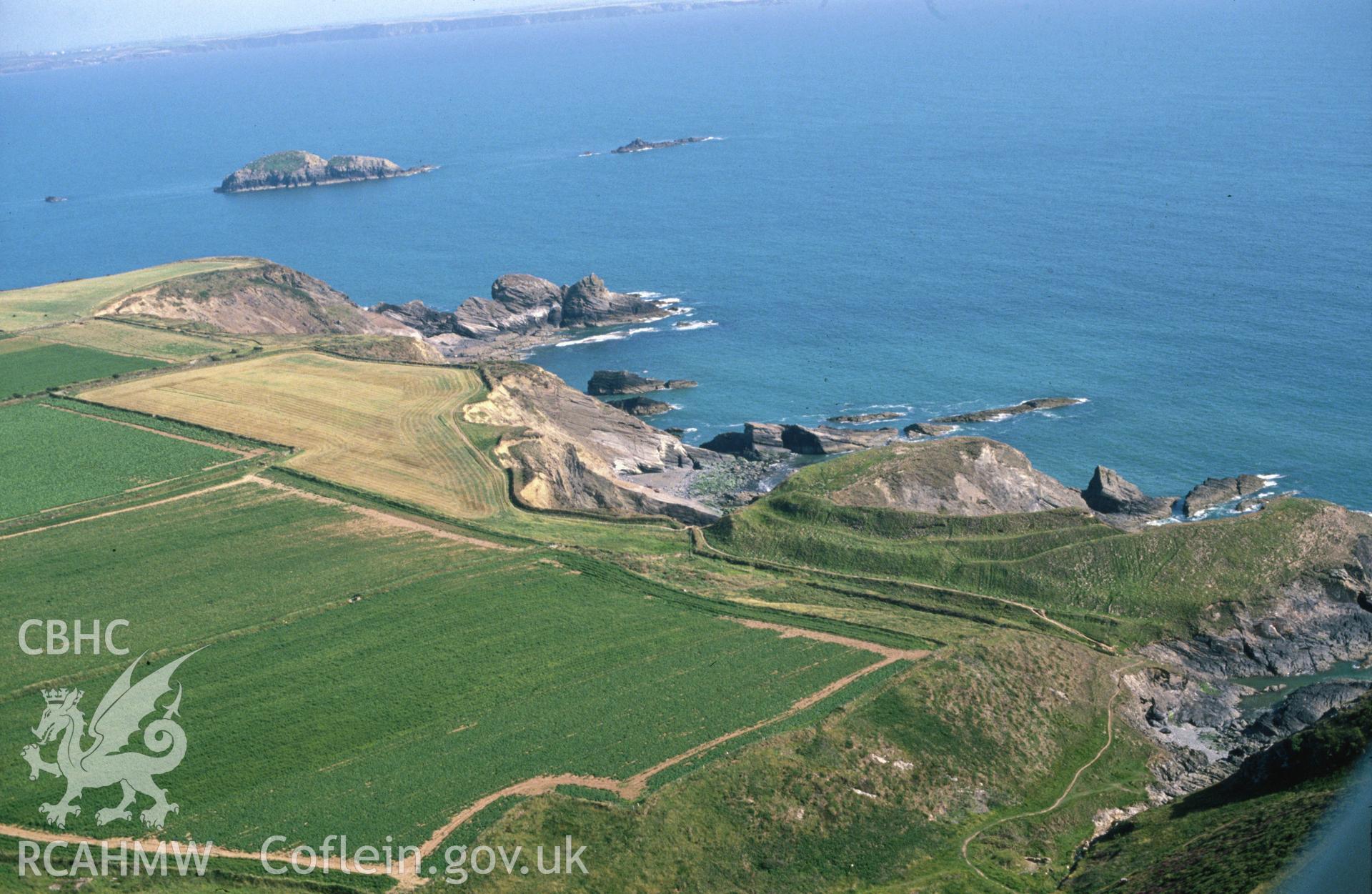 Slide of RCAHMW colour oblique aerial photograph of Porth-y-rhaw Promontary Fort, taken by C.R. Musson, 10/7/1990.