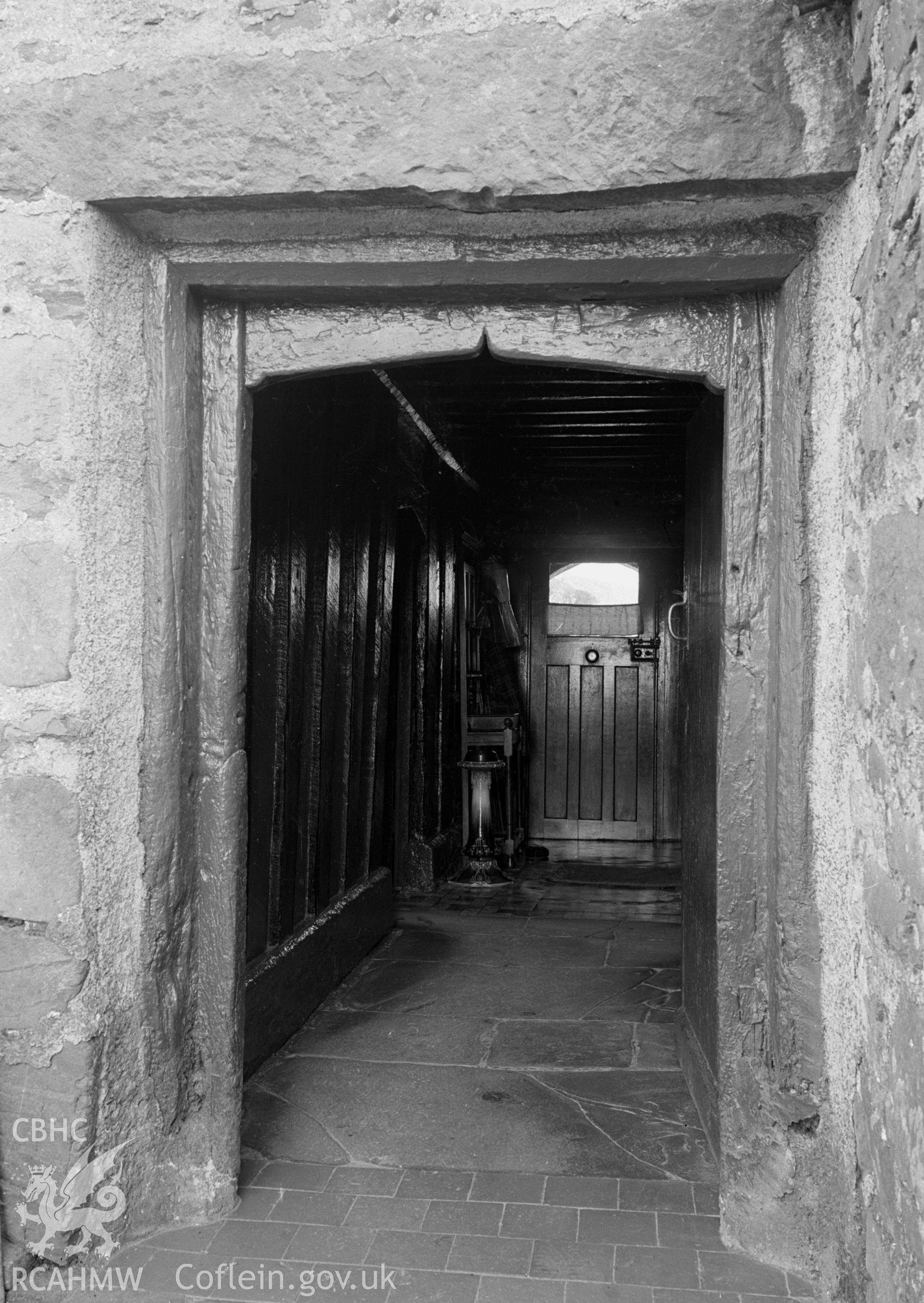 A rectangular north doorway leading into a hallway with stone slab floors.