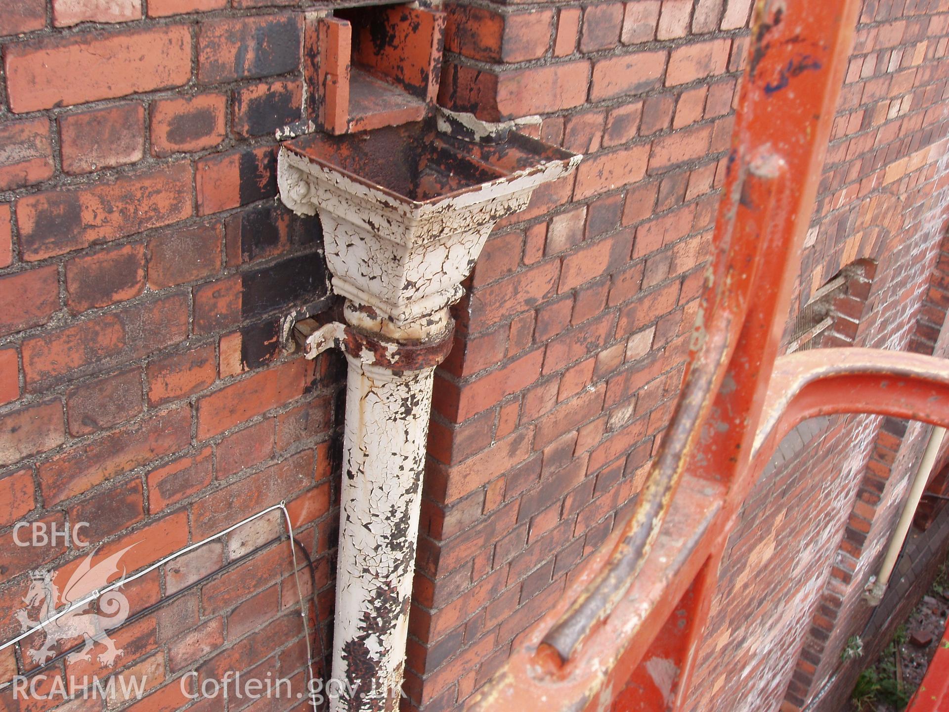 Colour digital photograph showing a drainpipe and part of an exterior wall of the Malt House, East Dock Road, Newport.  The photograph was taken after the building was severely damaged by fire.