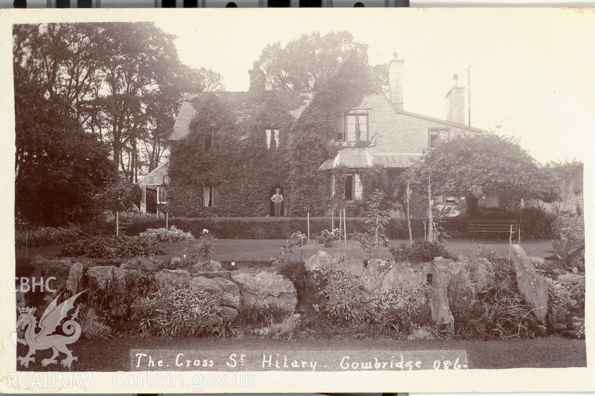 Digitised postcard image of the Cross, St Hilary, with figure. Produced by Parks and Gardens Data Services, from an original item in the Peter Davis Collection at Parks and Gardens UK. We hold only web-resolution images of this collection, suitable for viewing on screen and for research purposes only. We do not hold the original images, or publication quality scans.