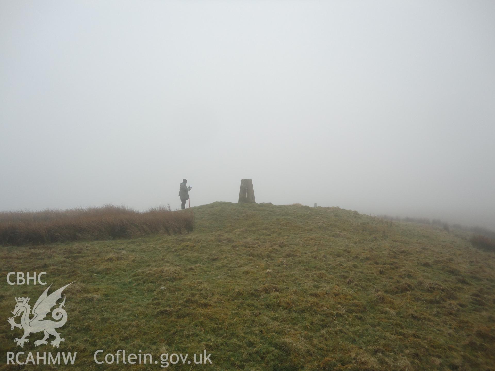 Cairn, with triangulation pillar NPRN 521460 inserted into the top of it, looking southwest.