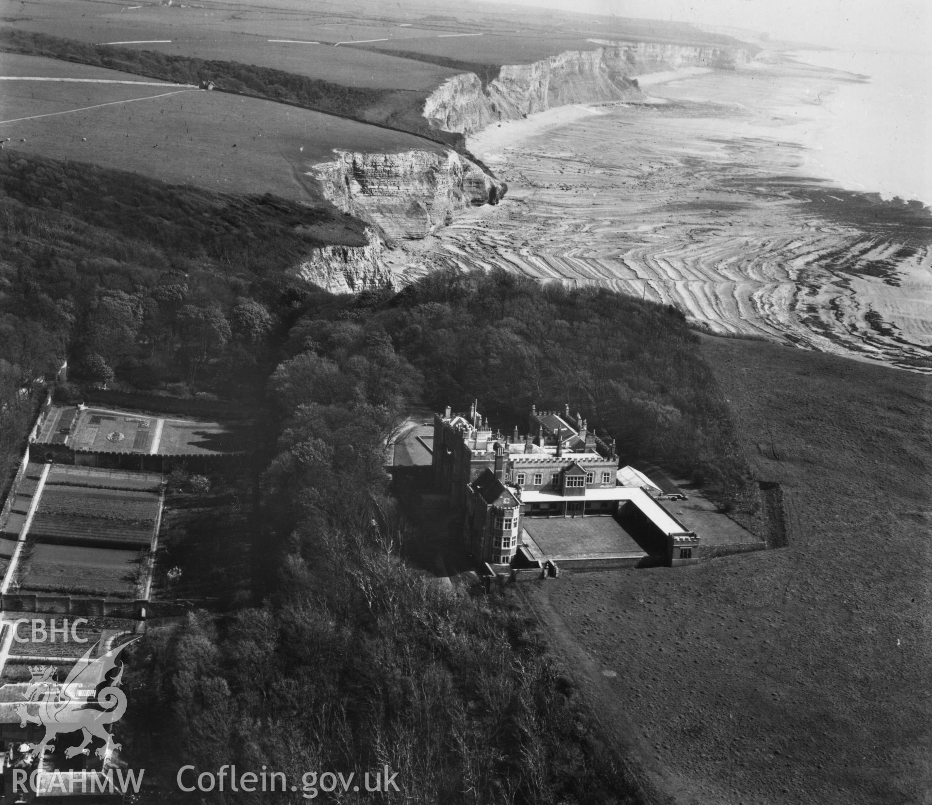 View of Dunraven Castle and gardens with cliffs and beach in background. Oblique aerial photograph, 5?" cut roll film.