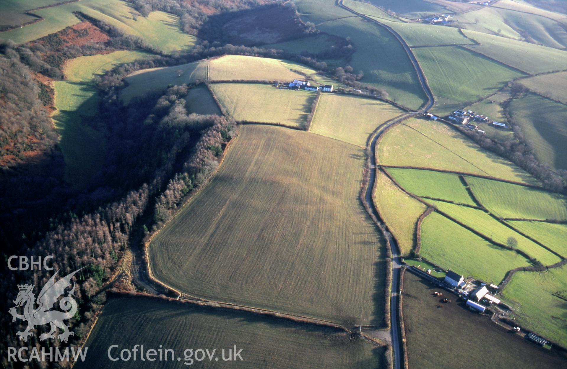 RCAHMW colour slide oblique aerial photograph of Gelli Diogyn, Enclosure Complex, Llanboidy, taken by C.R.Musson on the 02/02/1997