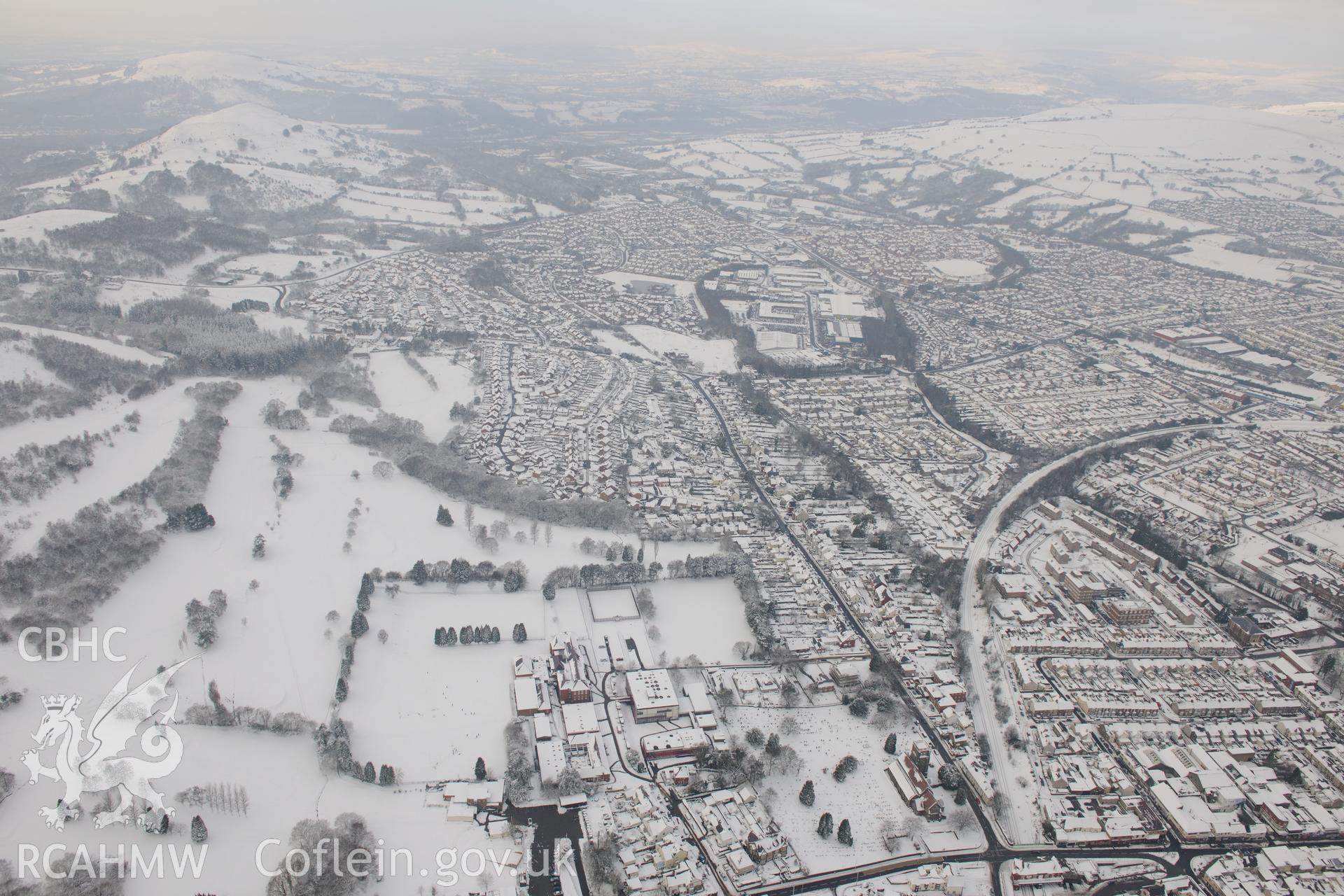 Caerphilly Castle and the town of Caerphilly. Oblique aerial photograph taken during the Royal Commission?s programme of archaeological aerial reconnaissance by Toby Driver on 24th January 2013.