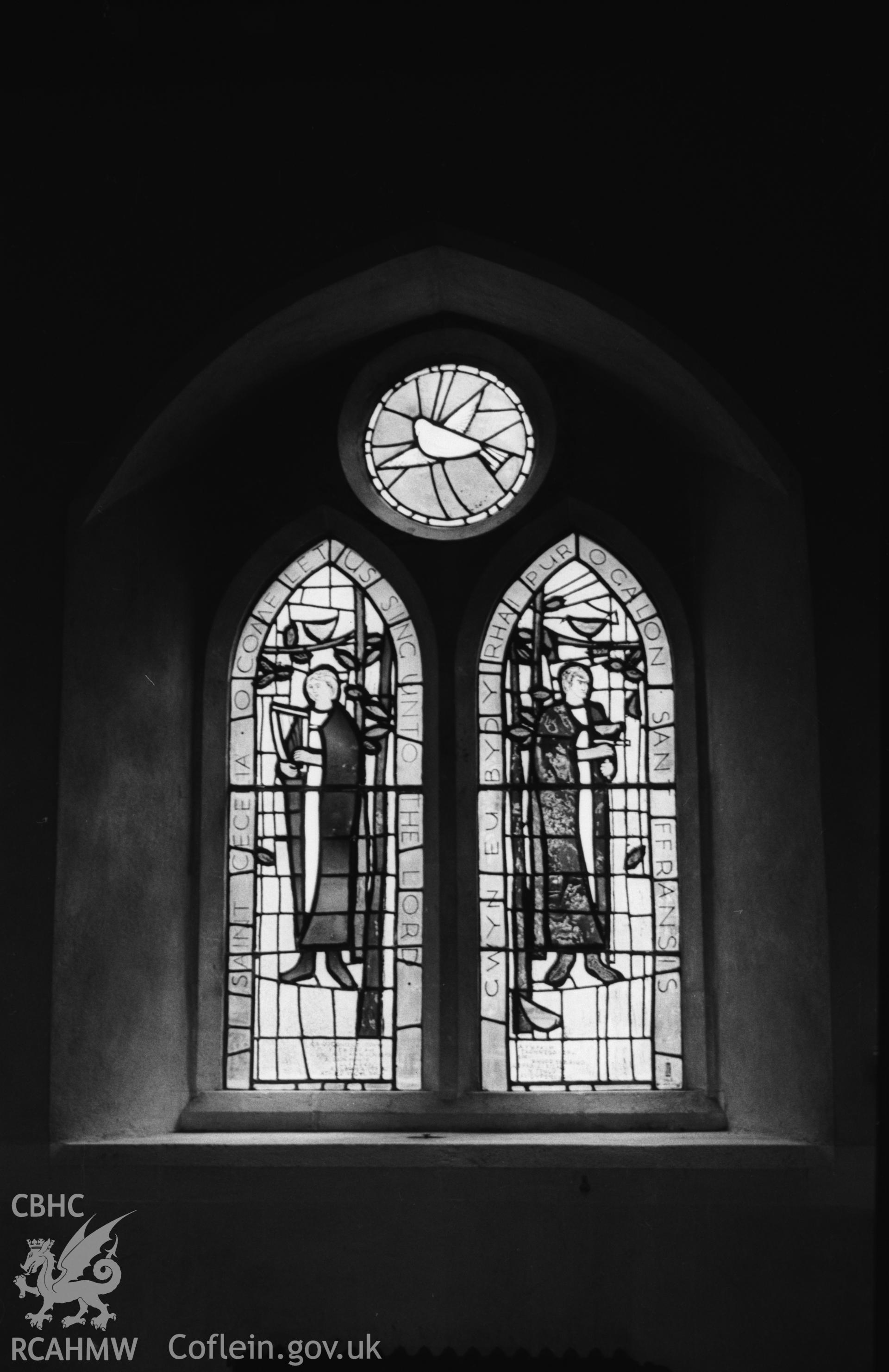 Digital copy of a black and white negative showing stained glass window to W.G. Jenkins: St Cecilia and St Francis, by Roy Lewis, 1963, in north wall of nave at St. Michael's church, Llandre. Photographed in April 1963 by Arthur O. Chater.