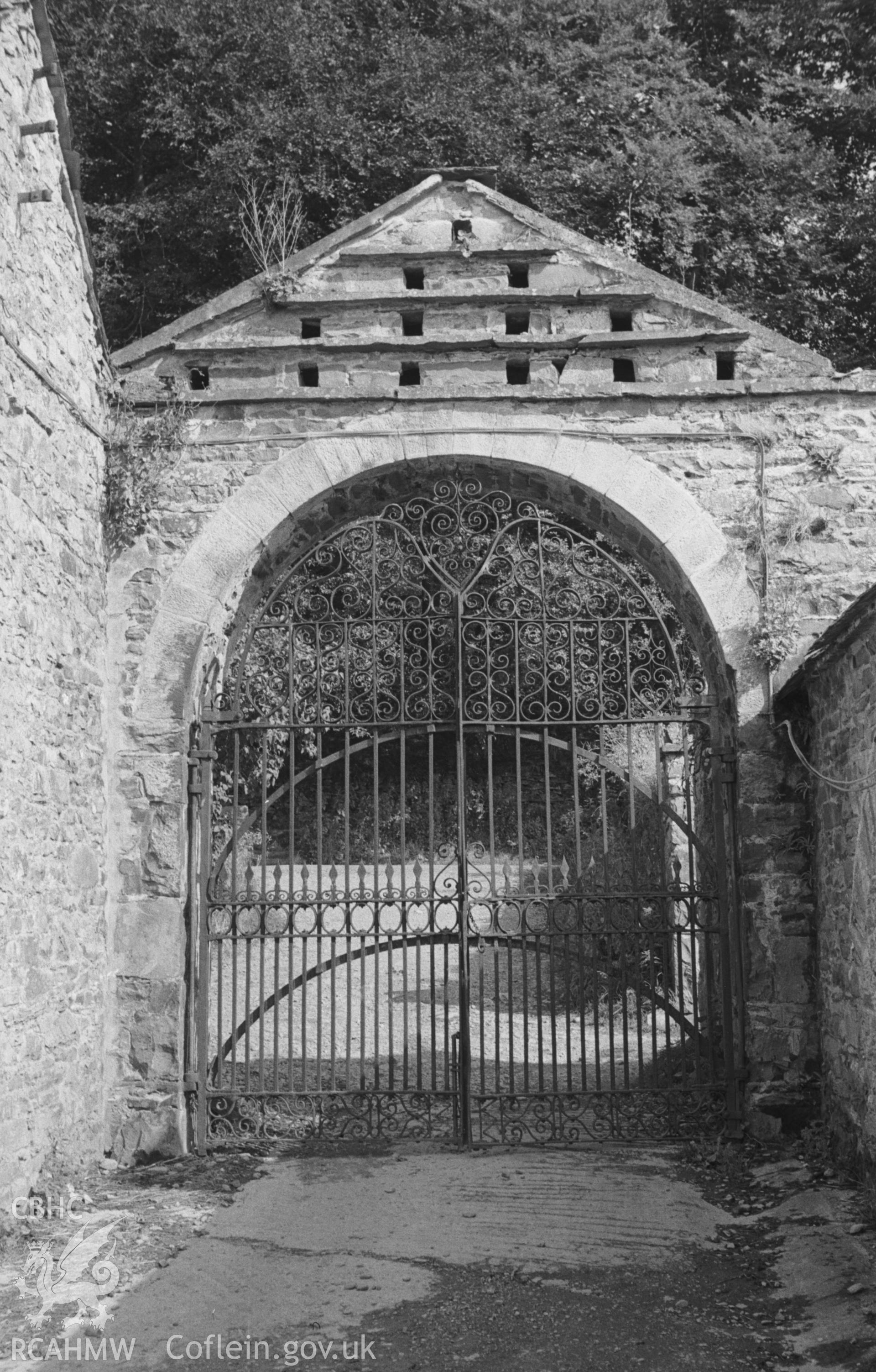 Digital copy of black & white negative showing ornate wrought iron gates at south east cornder of Llanfair farmyard, Llandysul, with dovecote above. Photographed by Arthur O. Chater in August 1965 from Grid Reference Sn 4332 0492, looking east south east.