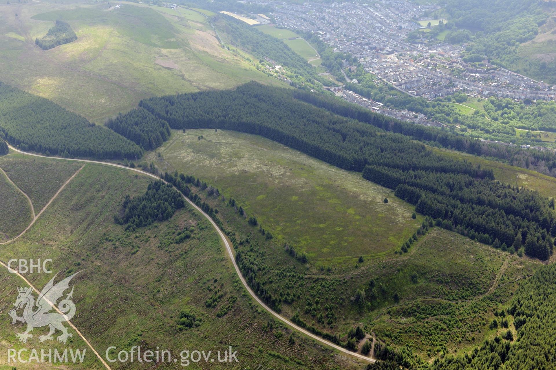 Twyn y Briddallt Roman Camp with the town of Ferndale beyond. Oblique aerial photograph taken during the Royal Commission's programme of archaeological aerial reconnaissance by Toby Driver on 11th June 2015.