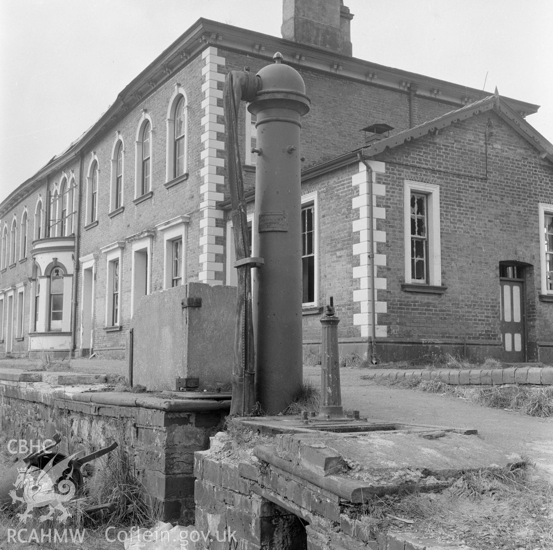 Digital copy of a black and white negative showing a view of the railtrack side elevation of Llanidloes Railway Station taken by Douglas Hague.