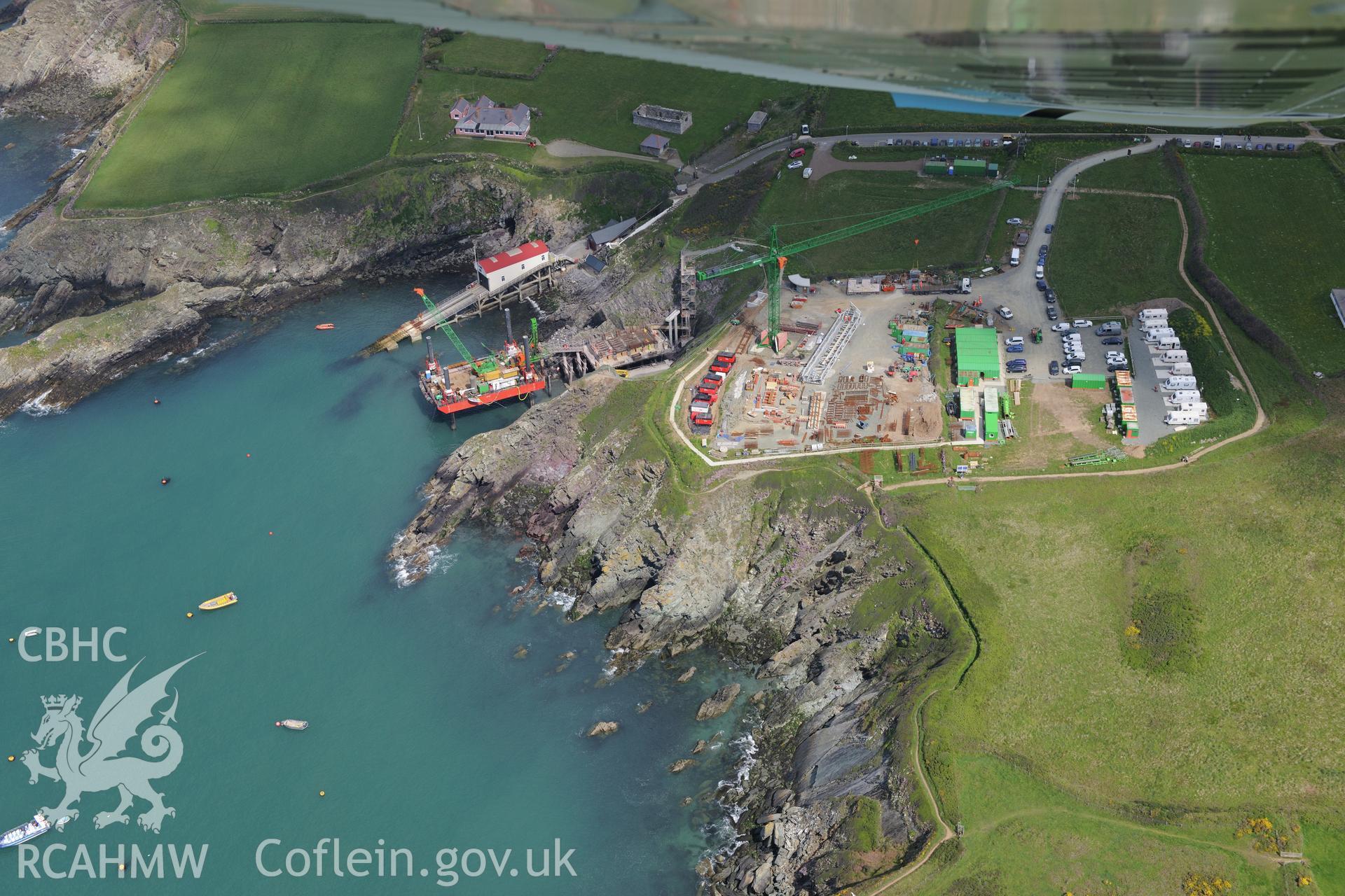 St Justinian's Chapel, St Justinian's bungalow, and St. David's old lifeboat station with the new station under construction. The floating mooring used by the crew whilst the station was being built is also visible. Oblique aerial photograph taken during the Royal Commission's programme of archaeological aerial reconnaissance by Toby Driver on 13th May 2015.