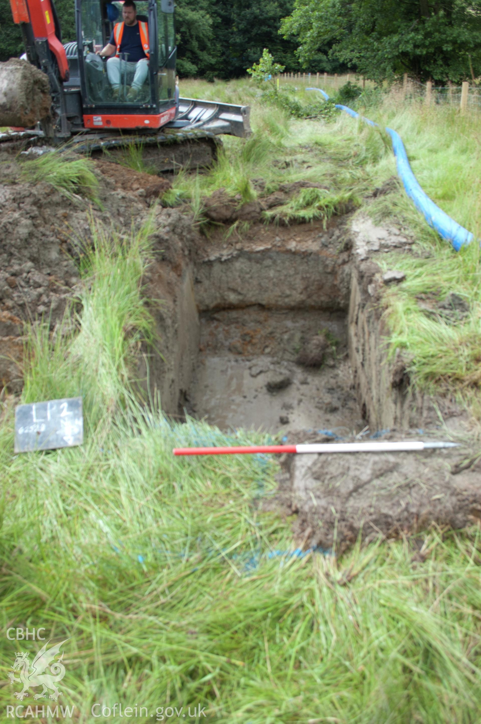 Digital photograph of view from north of launch pit 2 post-excavation showing grey clay fill. Photographed during Gwynedd Archaeological Trust's archaeological watching brief of water main renewal in Dolgellau on 28th July 2017. Project no. G2528.