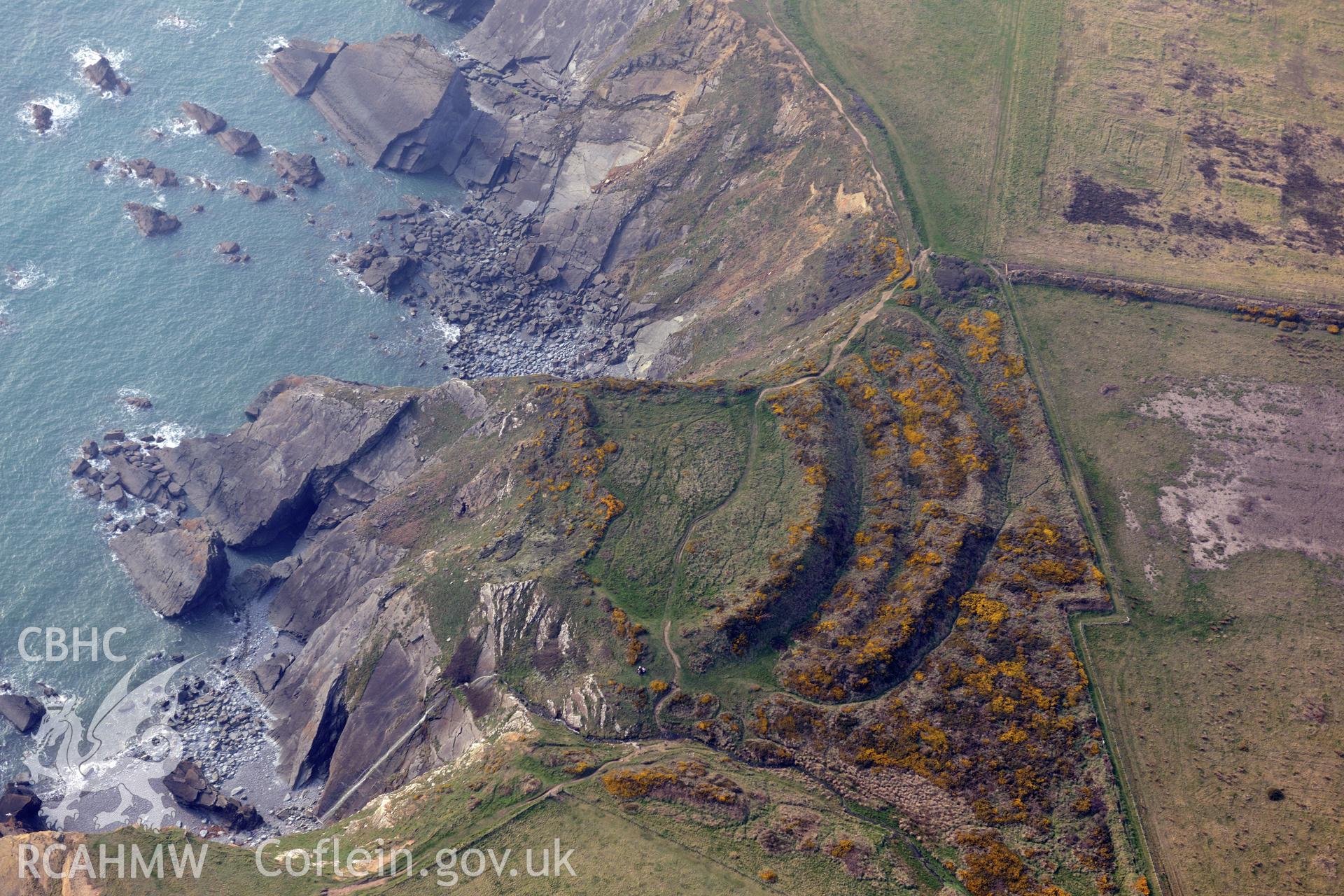 Aerial photography of Watery Bay Rath taken on 27th March 2017. Baseline aerial reconnaissance survey for the CHERISH Project. ? Crown: CHERISH PROJECT 2017. Produced with EU funds through the Ireland Wales Co-operation Programme 2014-2020. All material made freely available through the Open Government Licence.