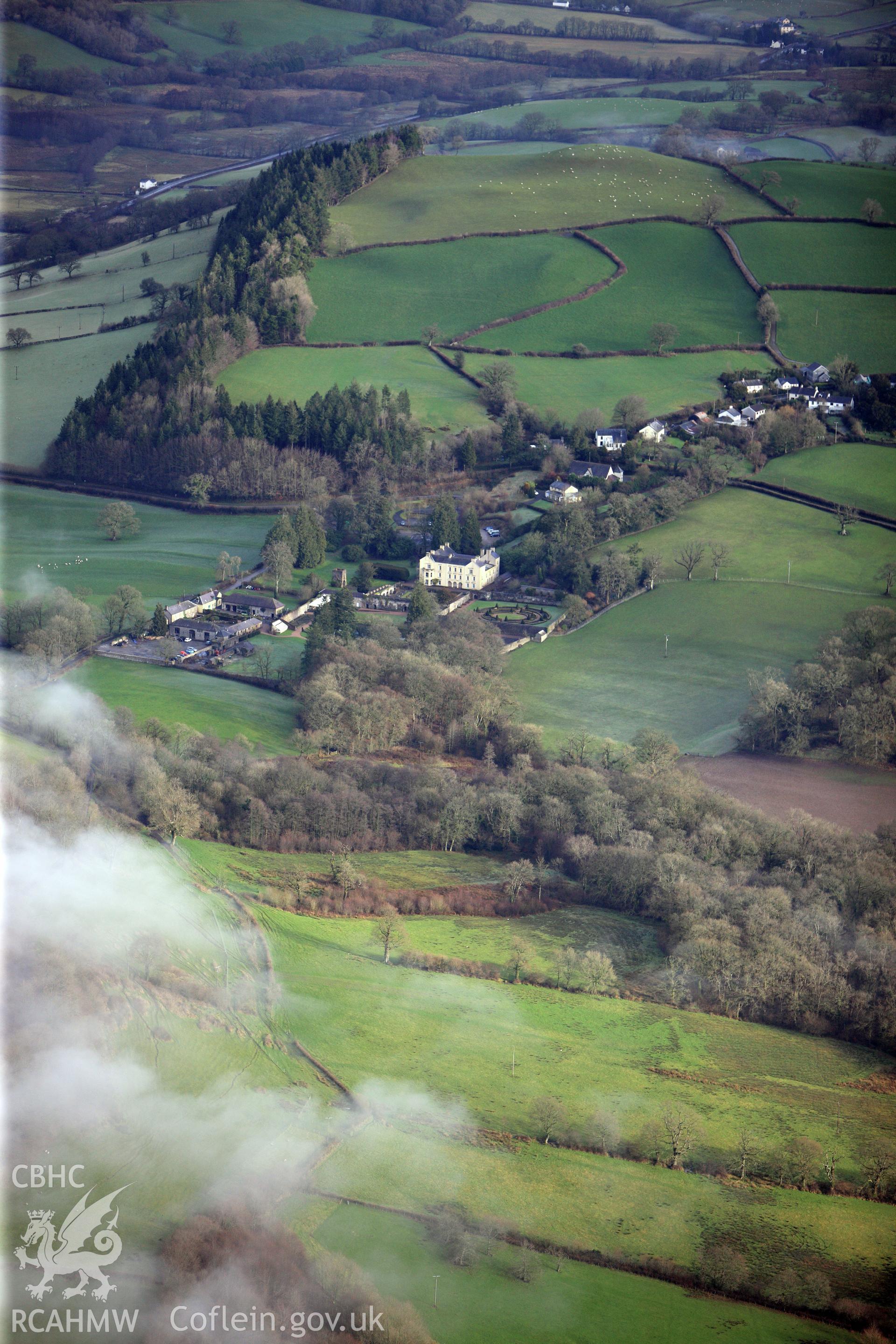 Aberglasney house, garden and south east courtyard range, with the village of Llangathen beyond. Oblique aerial photograph taken during the Royal Commission?s programme of archaeological aerial reconnaissance by Toby Driver on 15th January 2013.