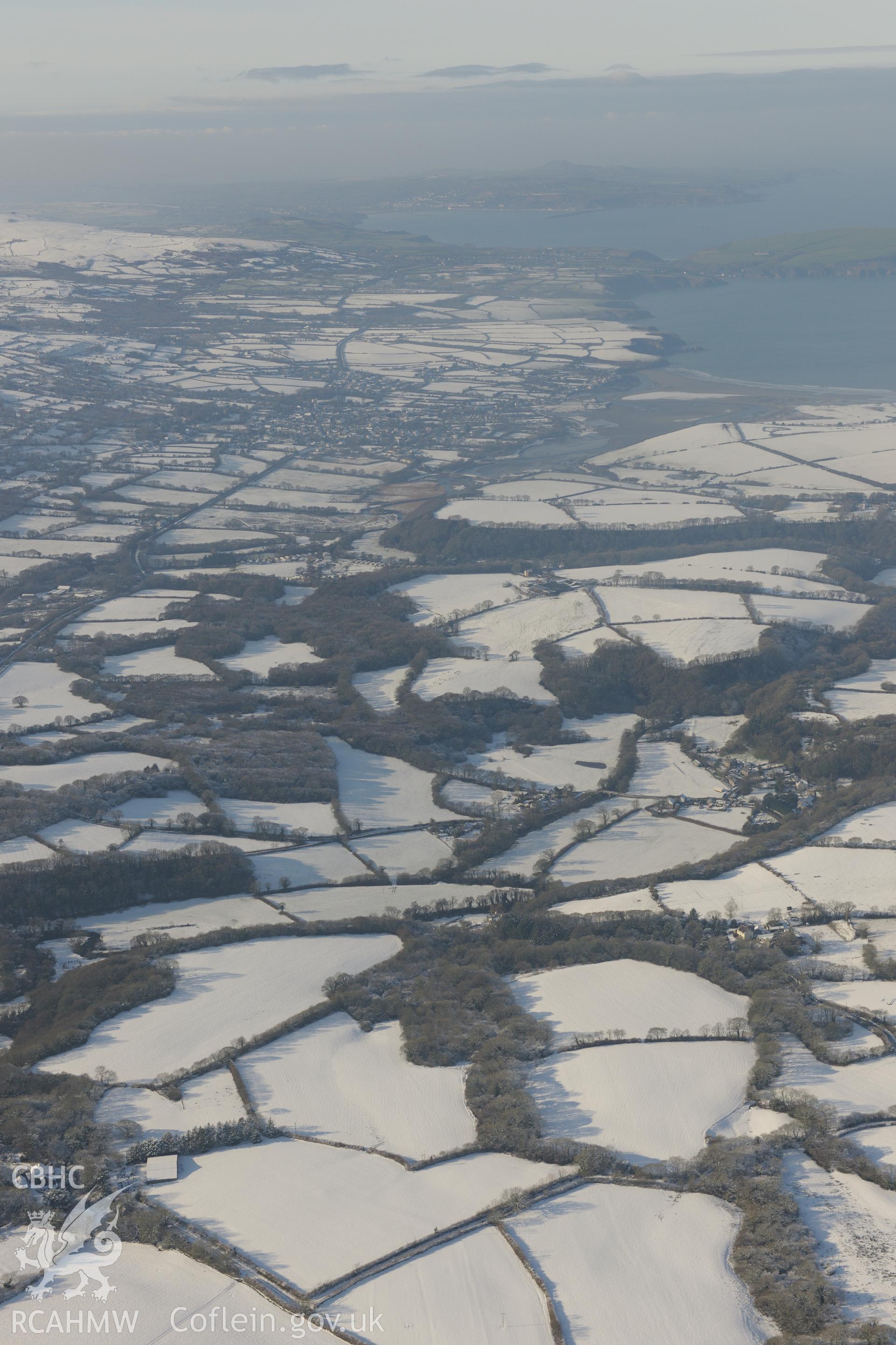 Nevern, Pembrokeshire, on the right of the photograph, with Newport on the banks of the Nyfer river beyond. Oblique aerial photograph taken during the Royal Commission?s programme of archaeological aerial reconnaissance by Toby Driver on 24th January 2013.