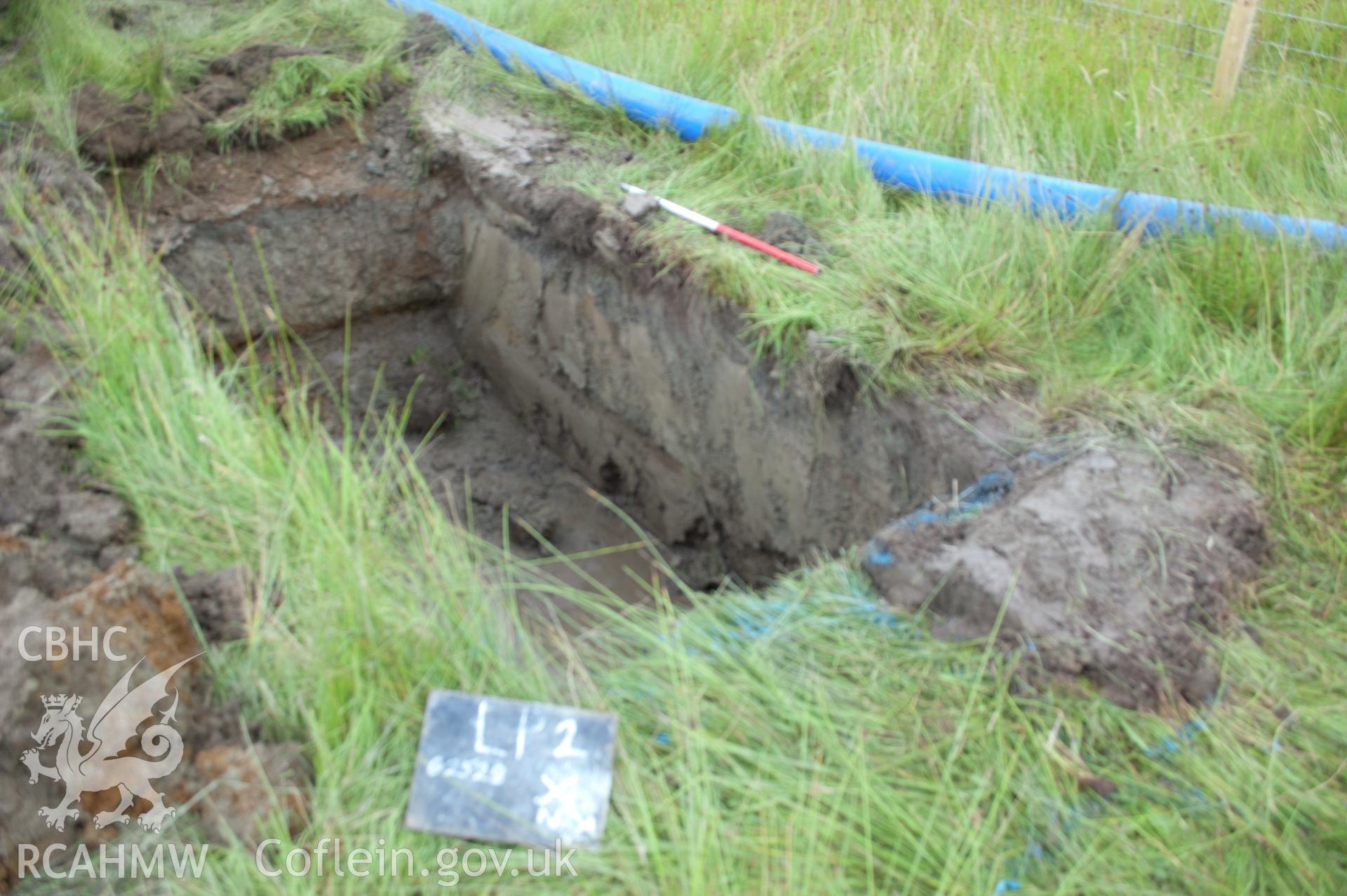 Digital photograph showing angled view from north east of launch pit 2 post-excavation. Photographed during Gwynedd Archaeological Trust's archaeological watching brief of water main renewal in Dolgellau on 28th July 2017. Project no. G2528.