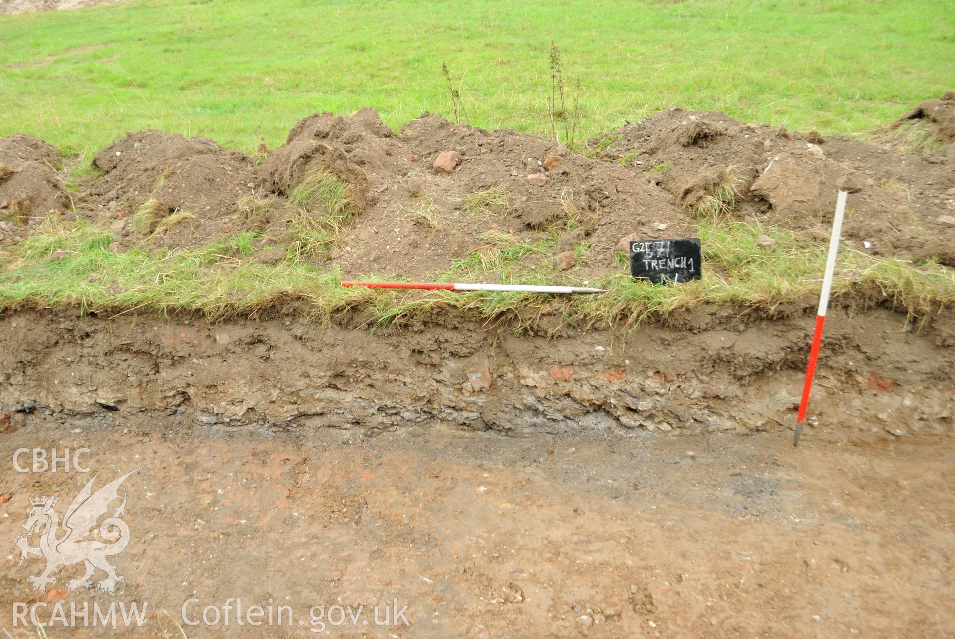 View from the north showing north facing section face of mid-point of Trench 1. Photographed during archaeological evaluation of Kinmel Park, Abergele, conducted by Gwynedd Archaeological Trust on 22nd August 2018. Project no. 2571.