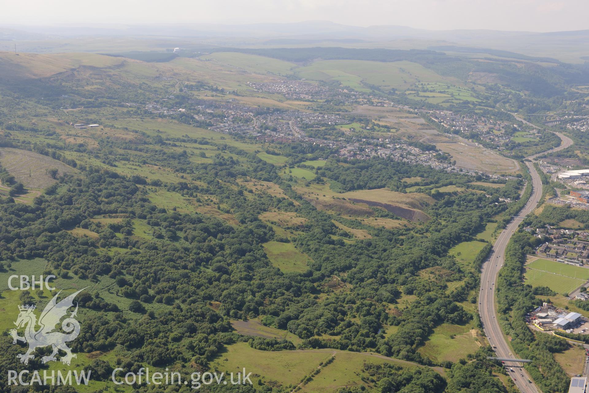 General view of the site of Cwm Pit colliery, with Merthyr Tydfil beyond. Oblique aerial photograph taken during the Royal Commission?s programme of archaeological aerial reconnaissance by Toby Driver on 1st August 2013.