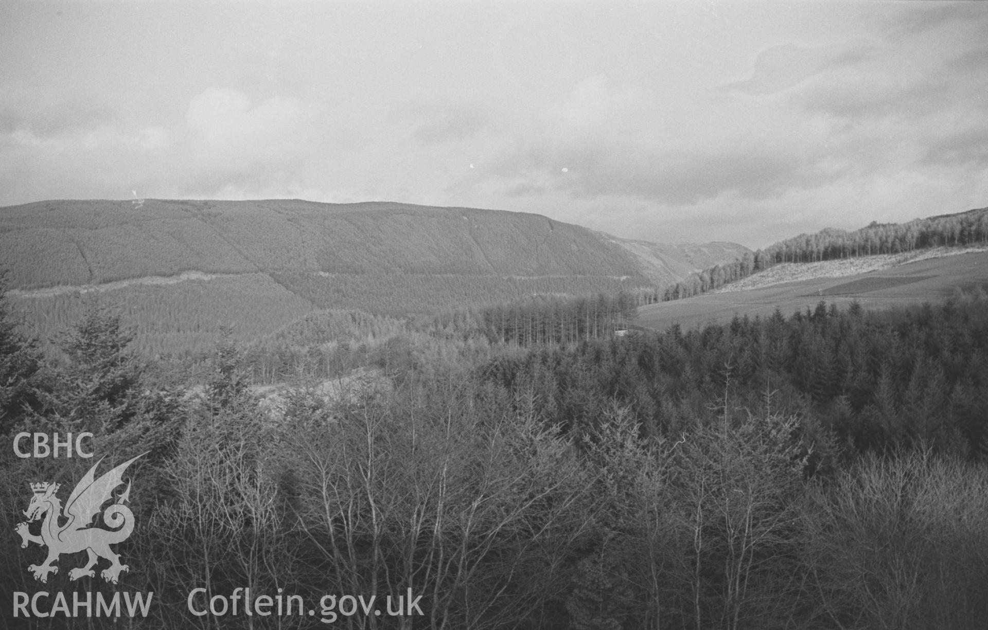 Digital copy of black & white negative showing Ystwyth Valley and forestry plantations from the disused railway embankment 800m south south west of Llanafan Bridge. Photograph by Arthur O. Chater, 31st December 1966, looking north east from SN 6845 7050.