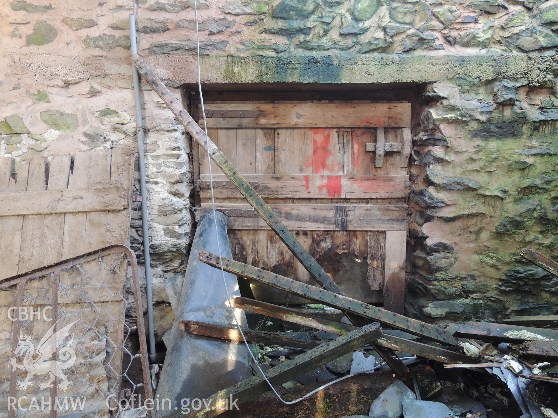 Panelled door from rear elevation, looking north. Photograph taken as part of archaeological building survey conducted at Bryn Gwylan Threshing Barn, Llangernyw, Conwy, carried out by Archaeology Wales, 2017-2018. Report no. 1640. Project no. 2578.