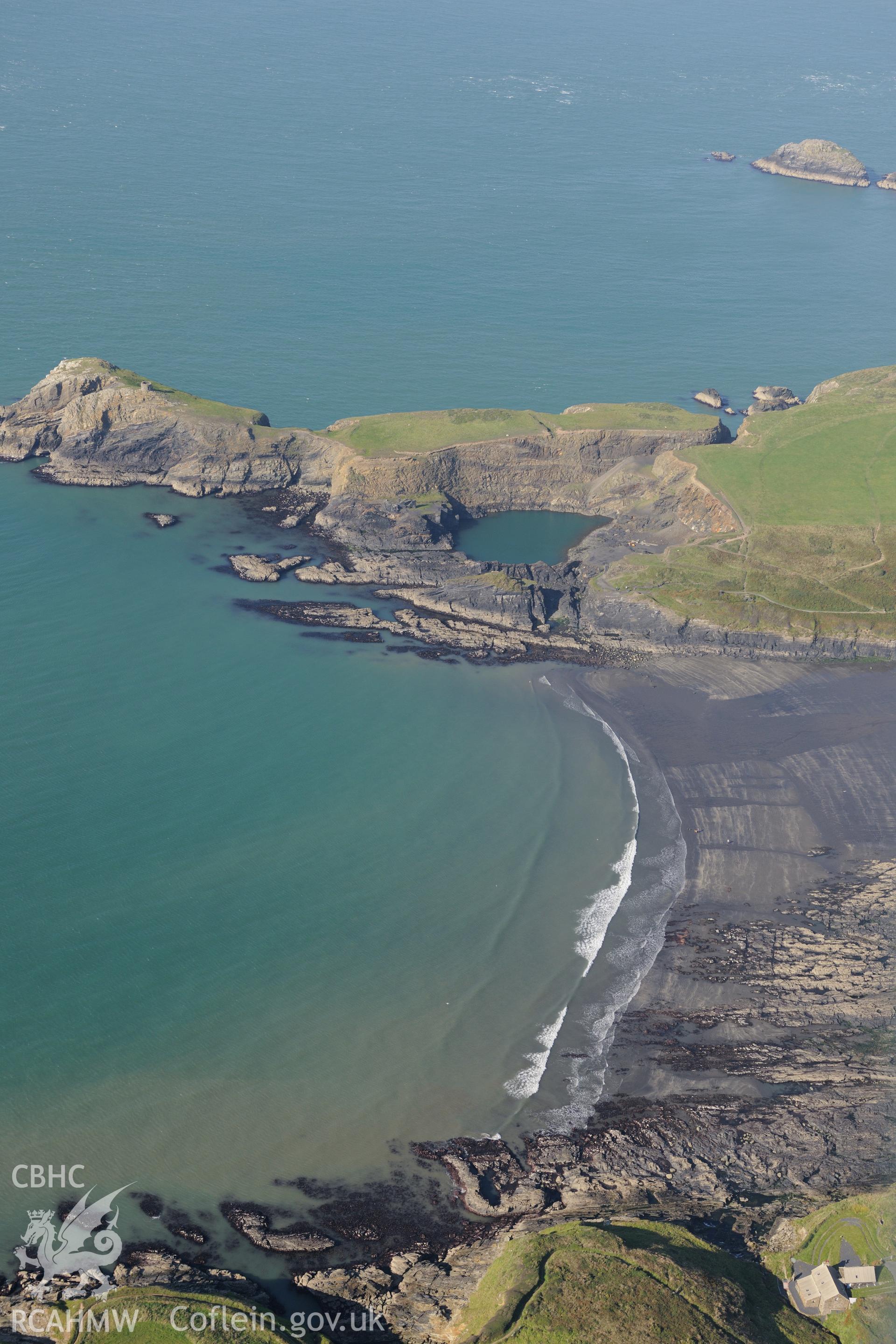 Remains of Porthgain slate quarry including engine house & lift, workshop & the old main quarry pit, now blue lagoon. Oblique aerial photograph taken during Royal Commission's programme of archaeological aerial reconnaissance by Toby Driver on 30/9/2015.