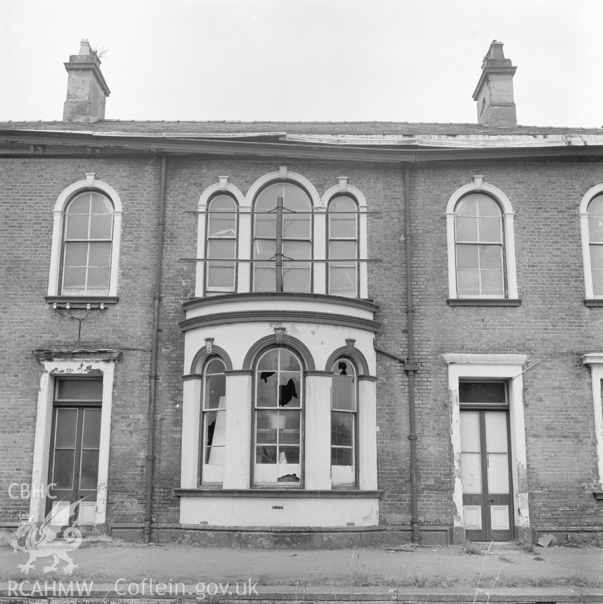 Digital copy of a black and white negative showing a view of the railtrack side elevation of Llanidloes Railway Station taken by Douglas Hague.