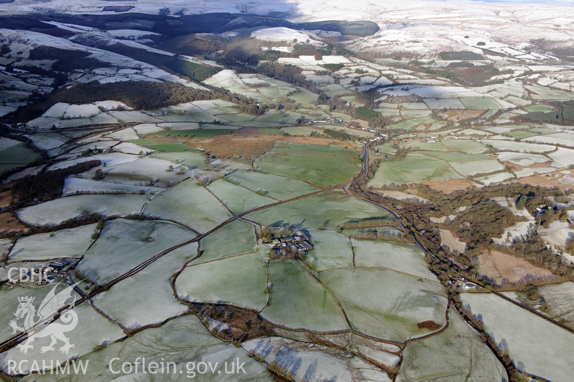 Twdin or Caerau Motte, Caerau Roman fort and military settlement, and the Roman road from Carmarthen to Castell Collen (RR623). Oblique aerial photograph taken during the RCAHMW?s programme of archaeological aerial reconnaissance by Toby Driver 15/01/2013.