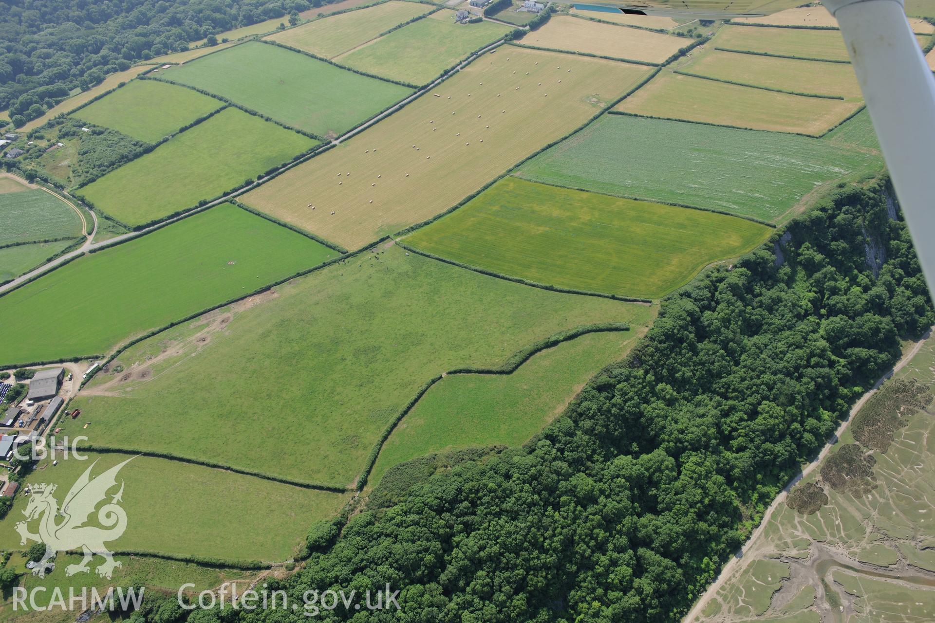 Bovehill Farm defended enclosure and Tor-Gro suggested enclosure, east of Cheriton, on the Gower Peninsula. Oblique aerial photograph taken during the Royal Commission?s programme of archaeological aerial reconnaissance by Toby Driver on 16th July 2013.