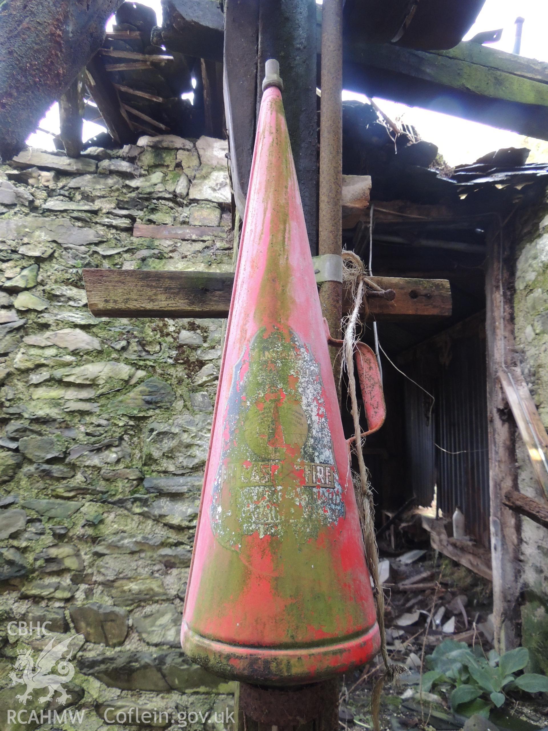 Detailed view of fire extinguisher. Photograph taken as part of archaeological building survey conducted at Bryn Gwylan Threshing Barn, Llangernyw, Conwy, carried out by Archaeology Wales, 2017-2018. Report no. 1640. Project no. 2578.