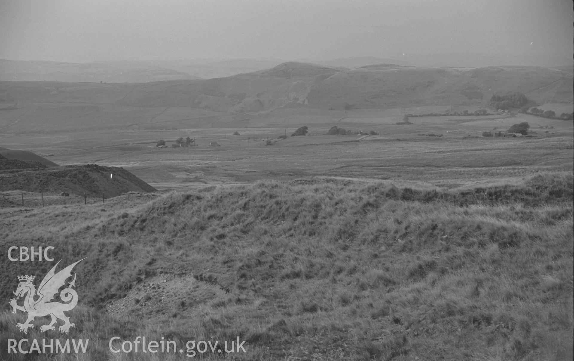 Digital copy of black & white negative showing view across old opencast workings of the late 18th century to main Esgair Mwyn Mine beyond; Glog-Fawr mine in distance on right. Photographed by Arthur O. Chater on 28th August 1966 from Grid Ref SN 756 691.