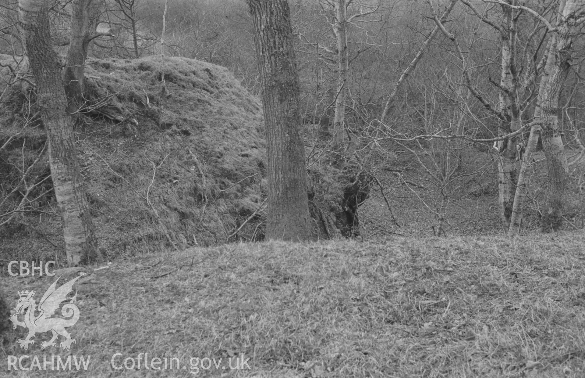 Digital copy of a black and white negative showing view looking north west at Castell Ystrad Peithyll motte at the fork in the road. Photographed in April 1963 by Arthur O. Chater.